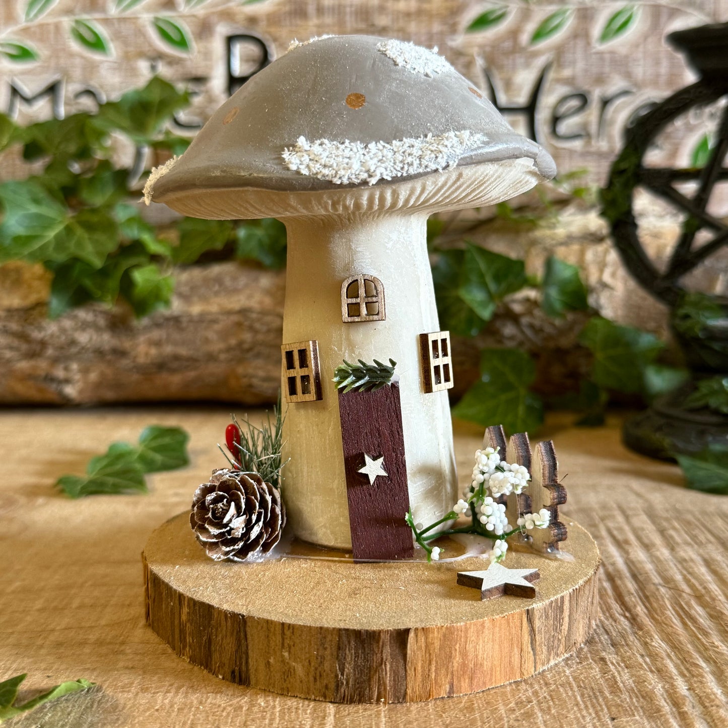 Decorative mushroom-shaped house on a wooden base with a natural background