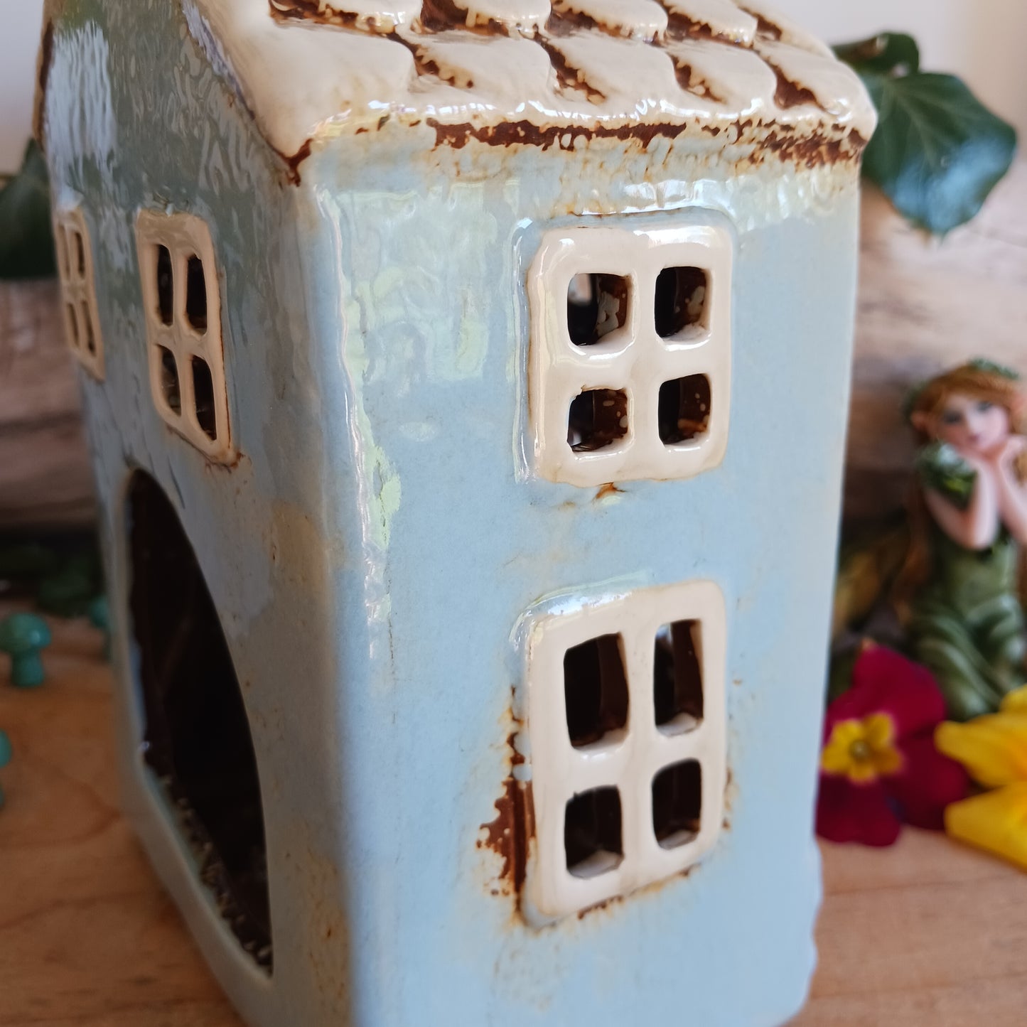 Add a touch of cozy charm and warmth to your home with the Village Pottery Heart House Tealight Holder in Blue. This delightful tealight holder is crafted to resemble a quaint little house, complete with heart-shaped cutouts that emit a soft, ambient glow when a tealight is placed inside. It can be displayed on a shelf, tabletop, or mantel, creating a cheerful and inviting atmosphere.