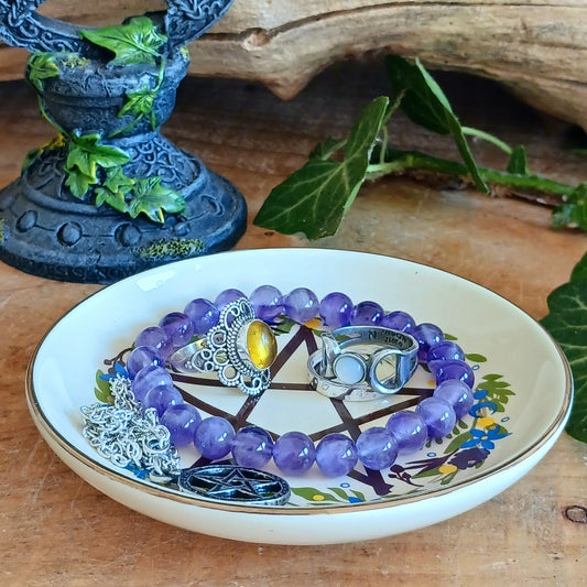 Add a touch of mystical charm to your home with this Solstice Wreath Pentagram Trinket Dish. Beautifully decorated with an elegant botanical pentagram design, this enchanting ceramic dish is perfect for keeping rings, crystals, earrings, necklaces and other tiny treasures safely stored in one place.