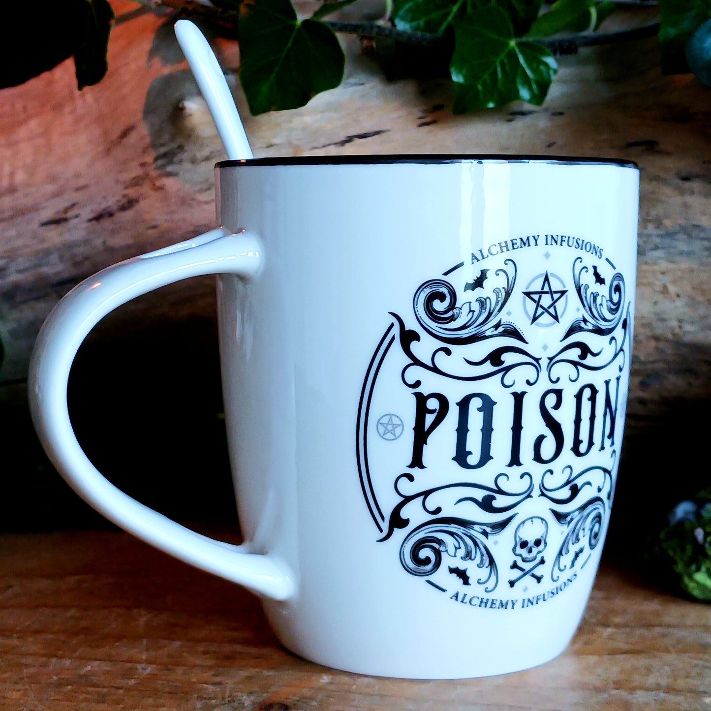 The Poison Mug & Spoon Set by Alchemy is crafted for those who know that beauty can deceive and danger can delight. Made from fine white bone china, this striking mug features intricate Alchemy artwork rich with symbolism — skull and crossbones, pentagrams, tiny bats, and ornate swirling patterns that whisper of alchemy, temptation, and forbidden power.