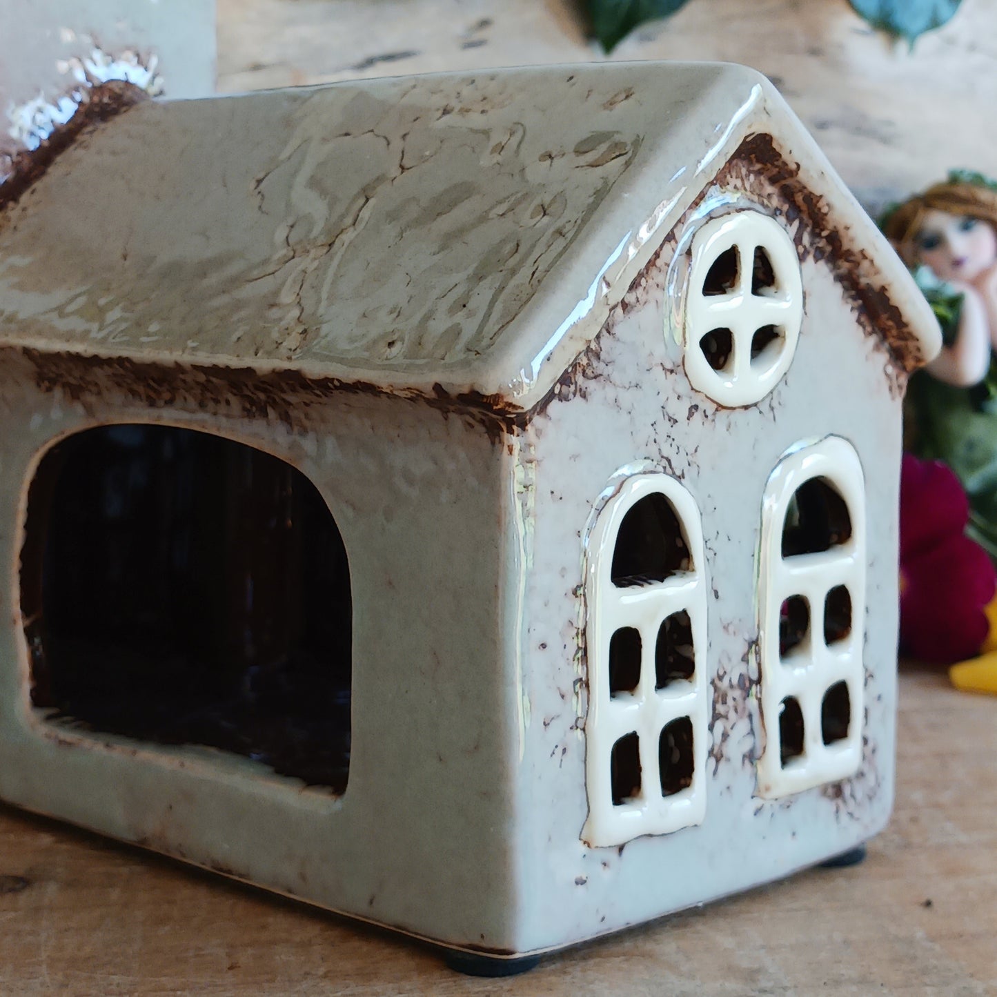 This charming ceramic Village Pottery Church tea light holder is a beautiful handcrafted piece, made to look old and natural. This church has a tall steeple, arched windows and is finished in abueaitful glaze. It can be displayed on a shelf, tabletop, or mantel, creating a cheerful and inviting atmosphere.