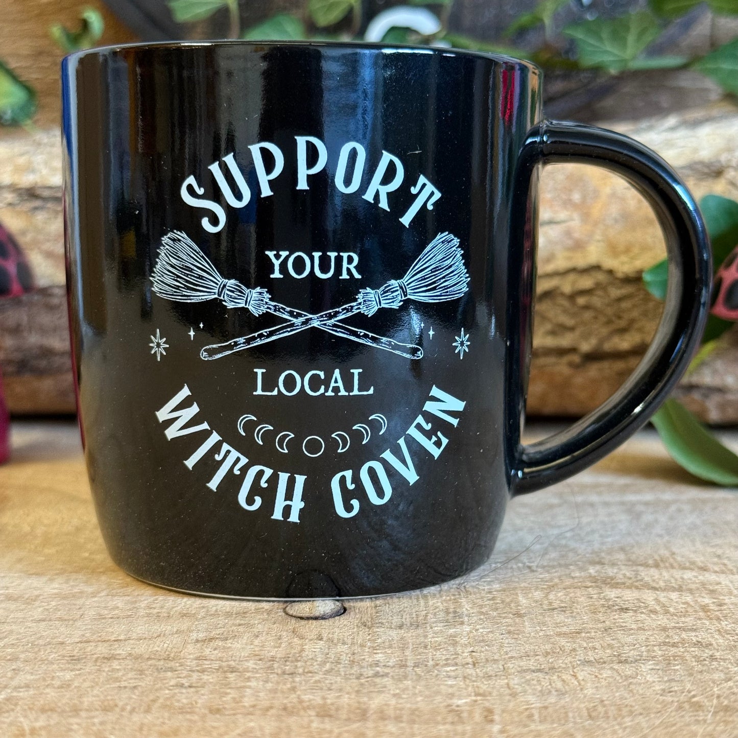 Show your support for all things magical with this black ceramic mug featuring crossed broomsticks and the phrase “Support Your Local Witch Coven.” Perfect for modern witches, mystical coffee lovers, and anyone who proudly backs their coven crew. With a 320ml capacity, it’s ideal for coffee, tea, or any magical potion. Microwave and dishwasher safe, this mug combines practicality with witchy style, making it a must-have gift or a charming addition to your own mystical collection.