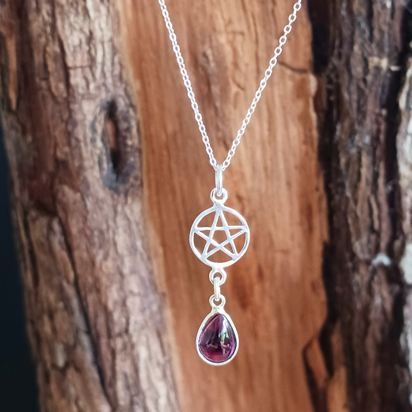 Beautifully handcrafted pentagram pendant in solid silver with a teardrop Garnet gemstone.&nbsp;&nbsp;   According to the Greek mathematician and philosopher Pythagoras, the pentagram&nbsp;represents the elements: Earth, Air, Fire and Water, with Spirit placed on the top. His followers, the Pythagoreans, saw it as mathematical perfection, which would later come to be known as the Golden ratio.