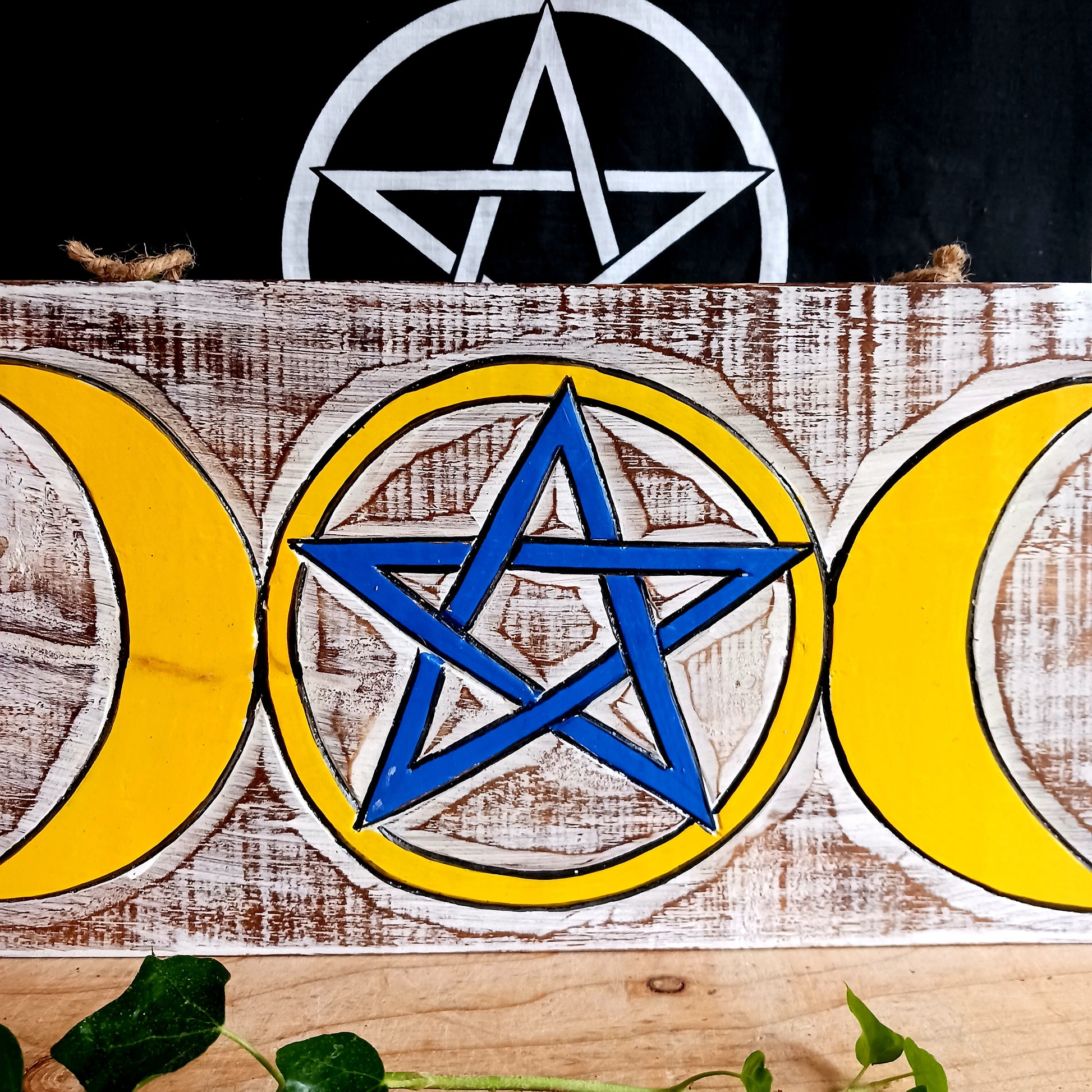 This cool wall plaque has a white wash effect with vibrant hand painted design featuring the triple goddess and pentacle symbols.&nbsp;  This lovely plaque comes with thick twine for easy hanging, perfect for any wall or door.