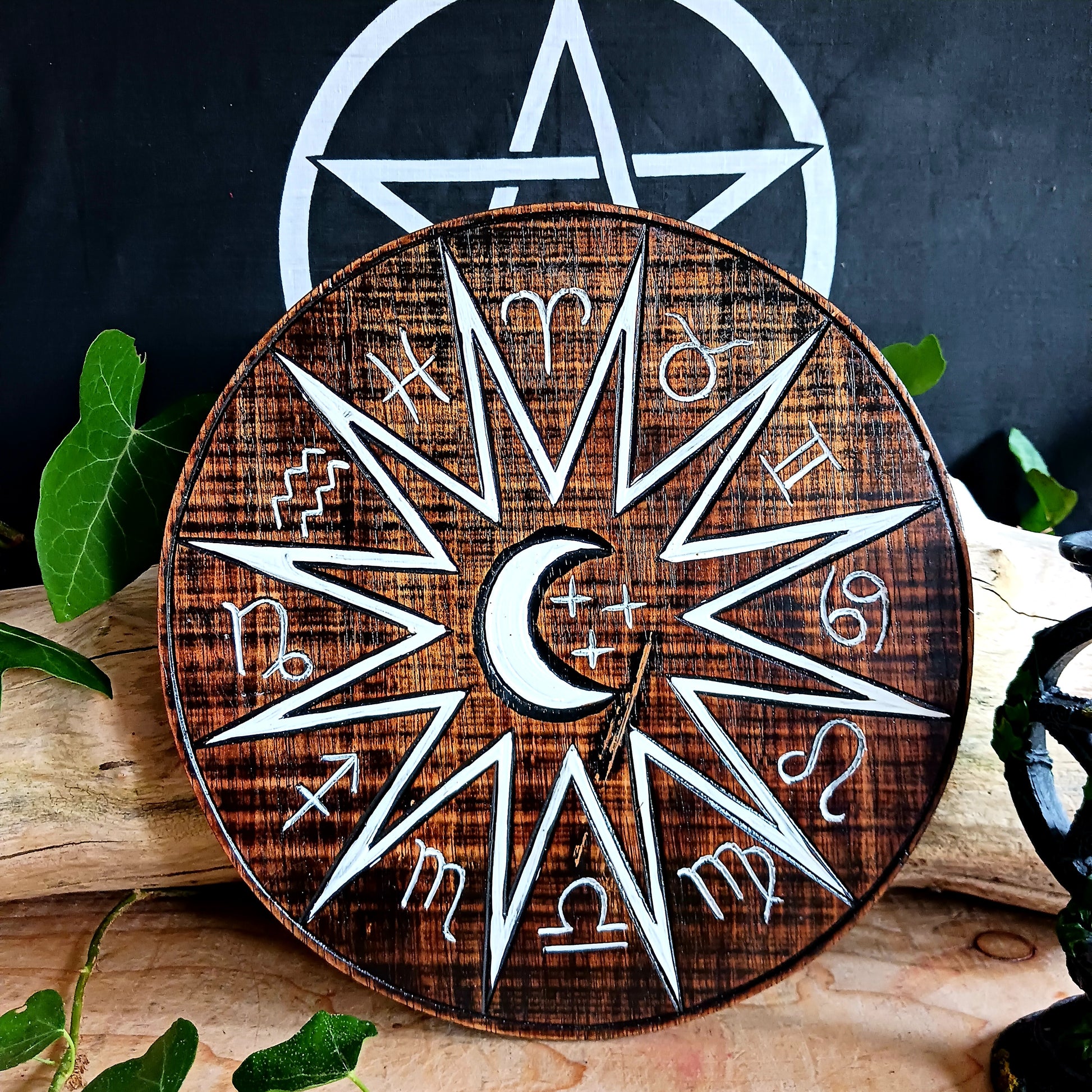 Hand carved and hand painted, this wooden wall plaque features a crescent moon and zodiac symbols design. This plaque comes complete with handy hanging hook.