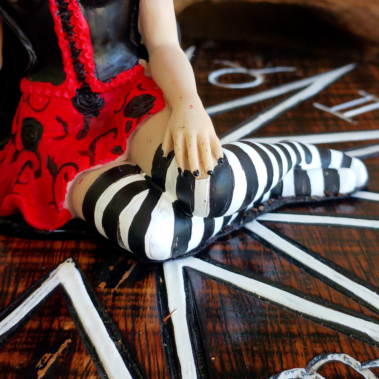 This stunning Fairy, Rosalia, was created by Fantasy brand Nemesis Now. She innocently sits with her striped legs extended to the side, wearing a black corseted dress that has a red skirt detailed with black roses.