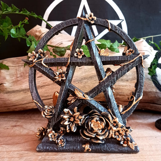 This stunning floral Pentagram is a captivating ornament designed by Nemesis Now for Wiccan enthusiasts.&nbsp;  Crafted with a resin black base, it features a striking pentagram adorned with exquisite gold flowers.  This beautiful piece will add a little mystical charm to your home or give as a perfect gift for loved ones, and for enthusiasts of Wiccan and Gothic decor.  Size: 16.5cm