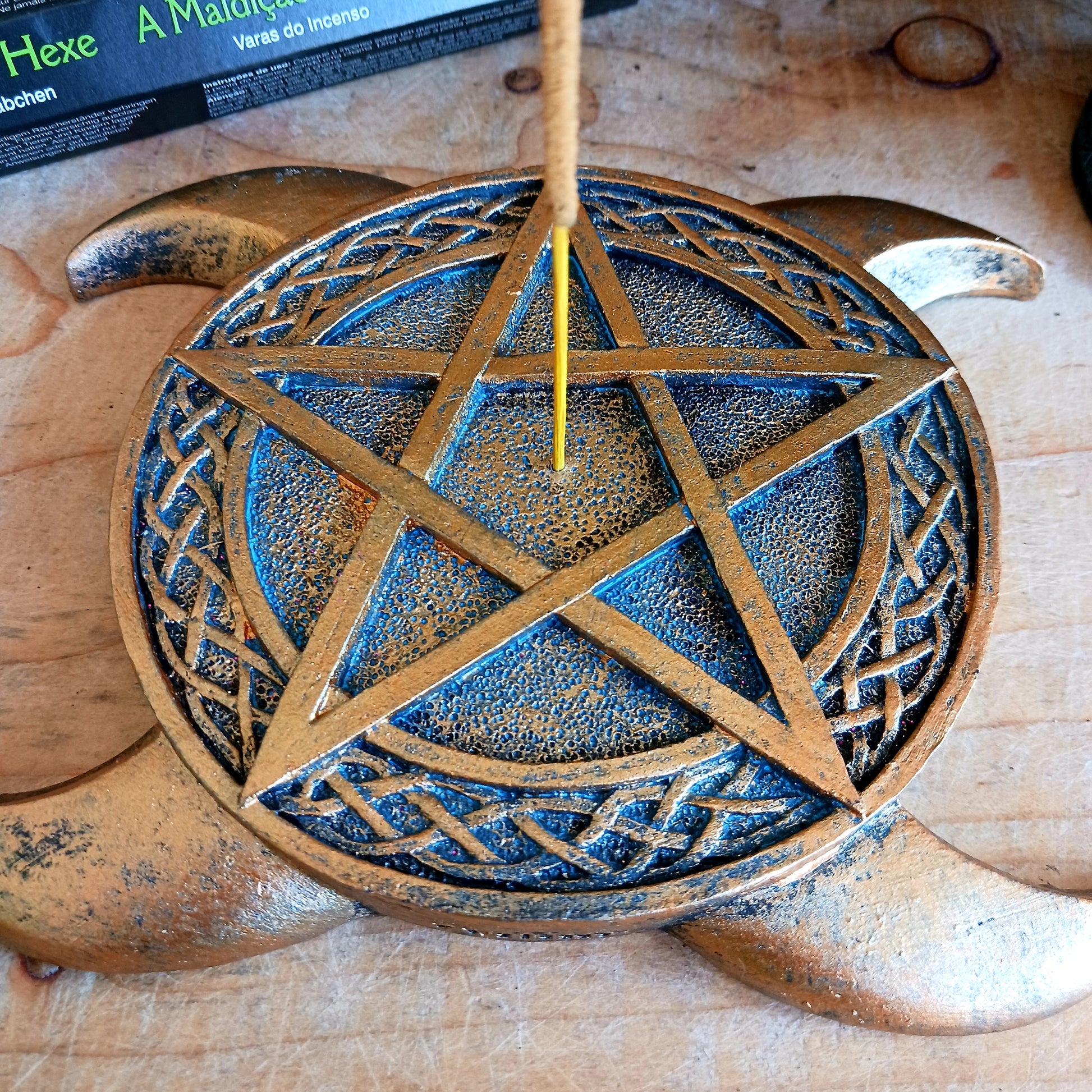 This Triple Moon Pentacle Incense Burner is cast in the finest resin before being given a high-quality bronze finish, shaped like the triple moon symbol, this piece lies on any flat surface. In the middle sits a pentagram with a central hole where you can place your favourite incense sticks.  The perfect gift for any spiritual follower.  Size: 15.5cm