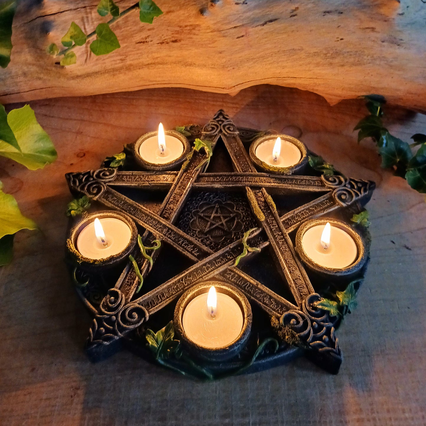 Wreathed in ivy and lichen, this tealight holder - created by Nemesis Now - is perfect for illuminating your home in more ways than one.  Cast in the highest quality resin, Celtic patterning and alchemist symbols reinforce the magic, while within the centre of the pentagram is another, smaller pentagram.  Holding 5 tealights, this piece is perfect for both lighting and ritual use, and is sure to make a stunning centre piece of any room.