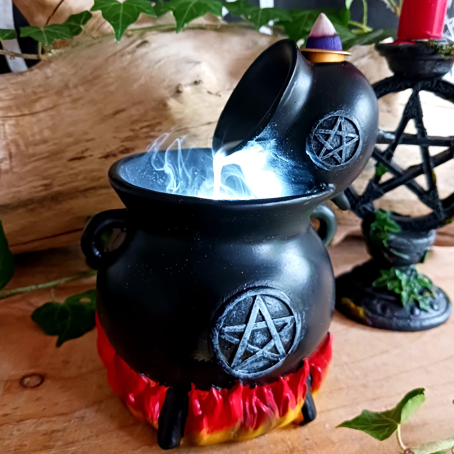 Place a backflow incense cone on top of this resin cauldron burner and watch the smoke&nbsp; gently pour between cauldrons. This burner is accented by flames at the bottom and a distressed silver-effect pentagram design.&nbsp; Finished with a light to create an outstanding smoke effect. Both fun and mesmerizing to watch!