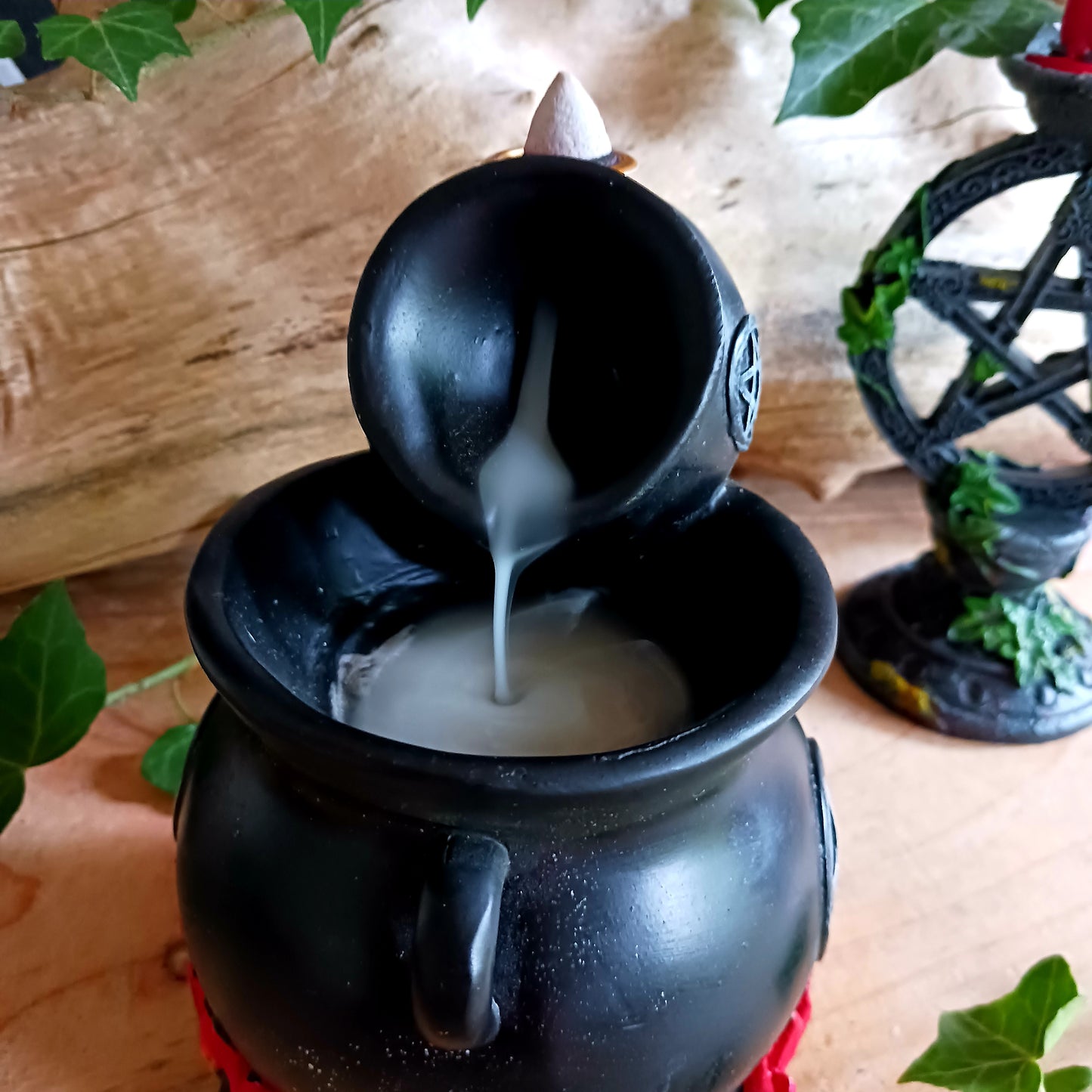 Place a backflow incense cone on top of this resin cauldron burner and watch the smoke&nbsp; gently pour between cauldrons. This burner is accented by flames at the bottom and a distressed silver-effect pentagram design.&nbsp; Finished with a light to create an outstanding smoke effect. Both fun and mesmerizing to watch!