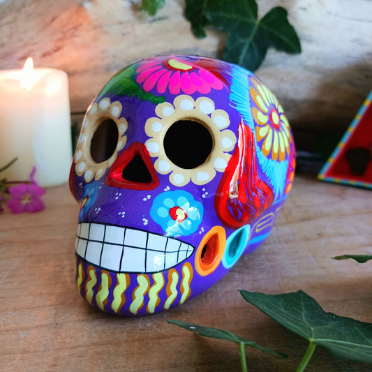 These fun ceramic sugar skull ornaments have been beautifully painted in bright colours and finished with a high shine glaze. They are a popular item during Día de Los Muertos or Day of the Dead festivities, held in Mexico every November to celebrate welcoming the souls of their deceased relatives back for a time of food, drink and celebration.