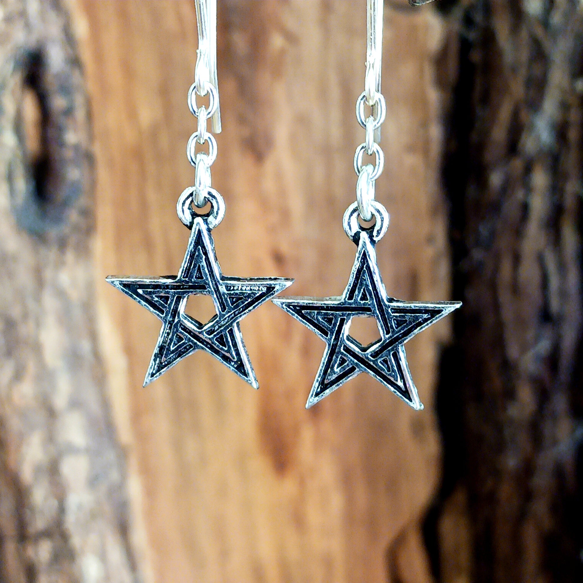 A pair of small, black enameled pewter pentagrams suspended a on fine chain and stainless steel ear-wires.