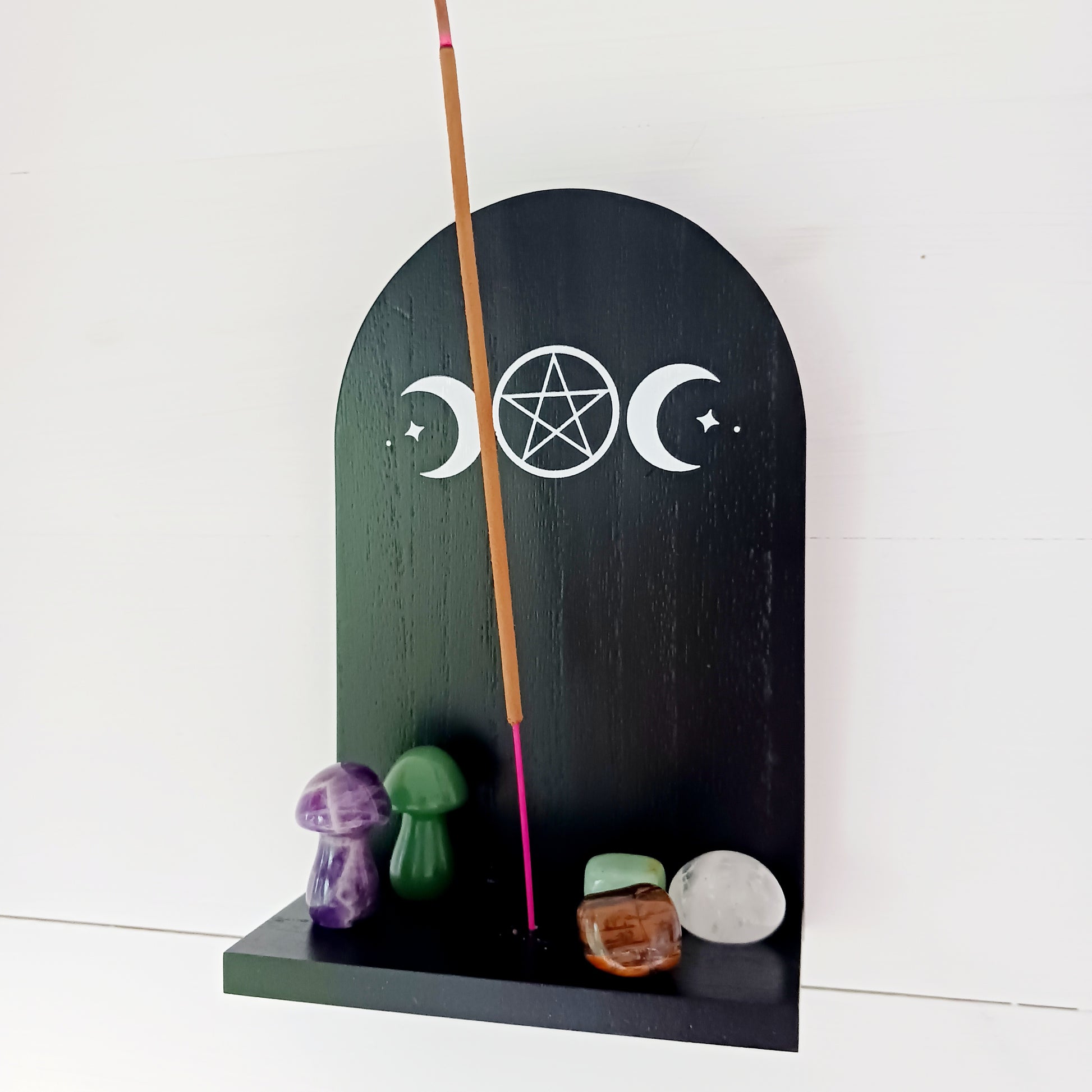 Add a touch of mystical ambiance and spiritual decor to your home with this black wooden incense shelf featuring a triple moon design, perfect for dispersing fragrance more freely.