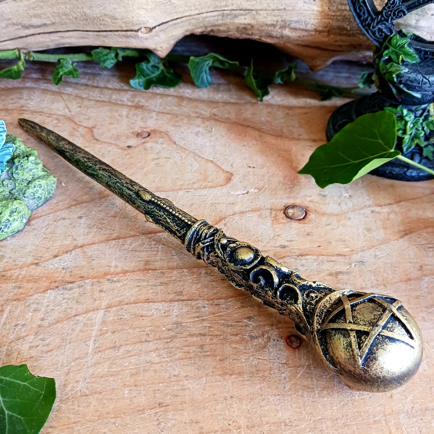 This enchanting wand features a bronze orb with pentagram symbol sitting atop an ornate and detailed wand stem. Elegant and appealing, this magic wand is a necessity for any witch or wizard's collection.