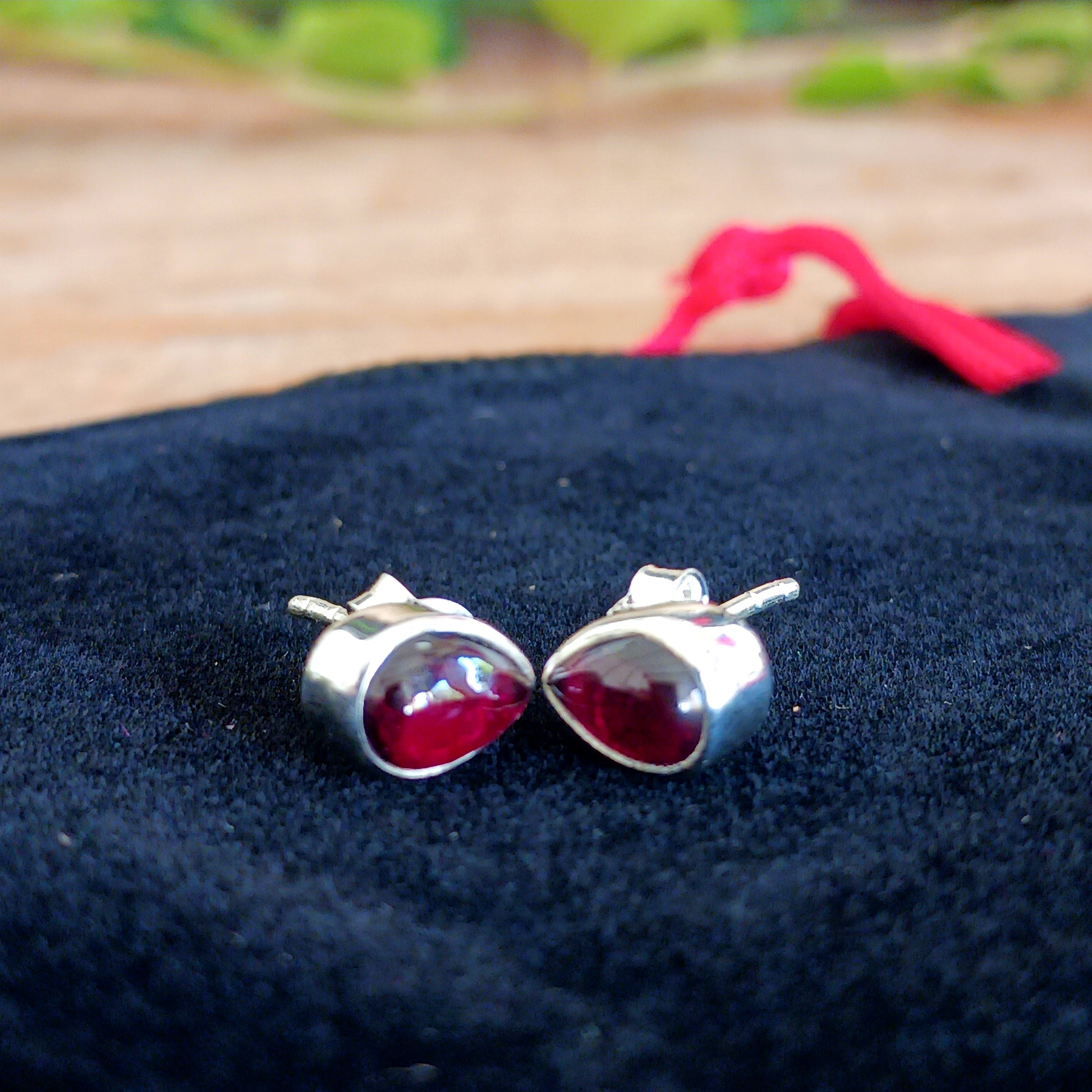 These handcrafted teardrop sterling silver studs have beautiful deep red Garnet gemstones that offer a touch of timeless elegance and vibrant colour.