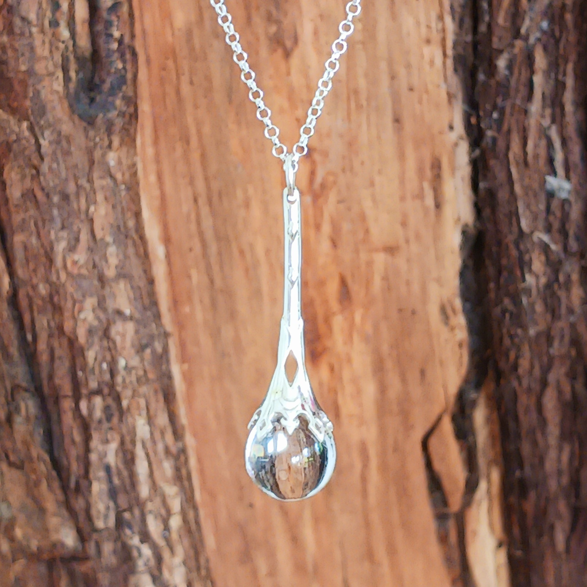 This Crystal Ball and Wand Pendant is made with with exquisite detail, featuring a 925 Sterling Silver Scrying Wand and a clear Quartz Crystal Ball.&nbsp; The clear Quartz Crystal Ball is set in sterling silver which has been carved in places to allow the light to shine down through the wand to give the ball more clarity.