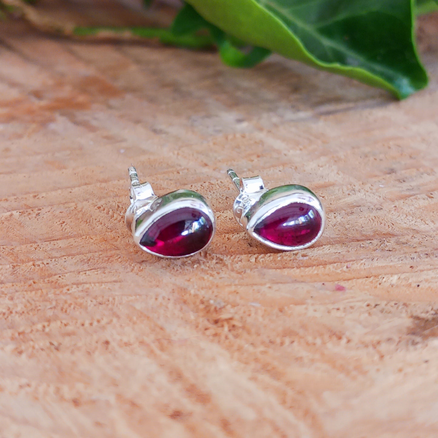 These handcrafted teardrop sterling silver studs have beautiful deep red Garnet gemstones that offer a touch of timeless elegance and vibrant colour.