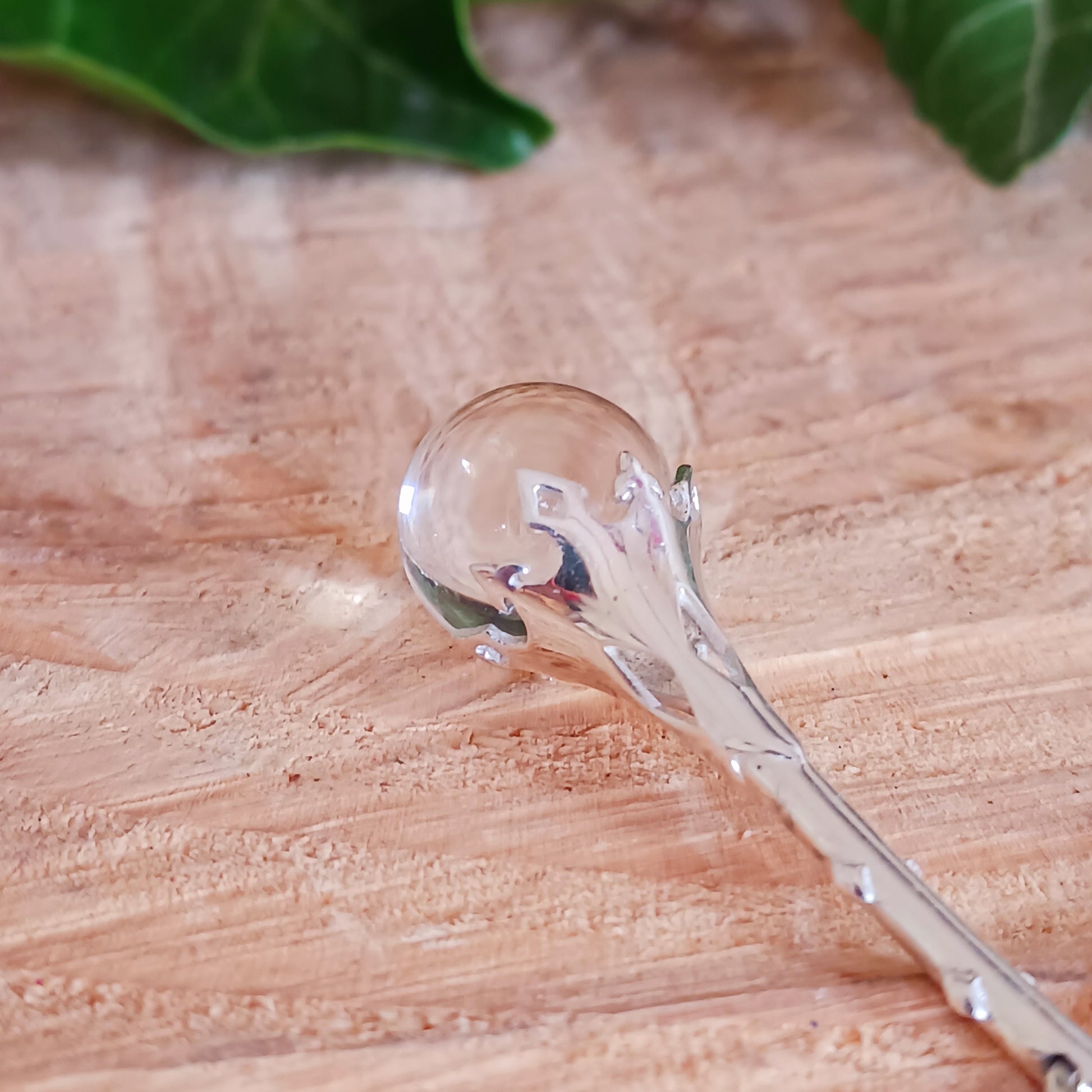 This Crystal Ball and Wand Pendant is made with with exquisite detail, featuring a 925 Sterling Silver Scrying Wand and a clear Quartz Crystal Ball.&nbsp; The clear Quartz Crystal Ball is set in sterling silver which has been carved in places to allow the light to shine down through the wand to give the ball more clarity.