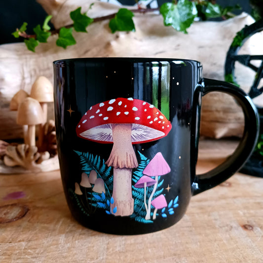 Add a touch of enchantment to your morning cuppa with this dark forest mushroom ceramic mug. This black ceramic mug features a captivating and intricate mushroom design, including a crescent moon and stars.