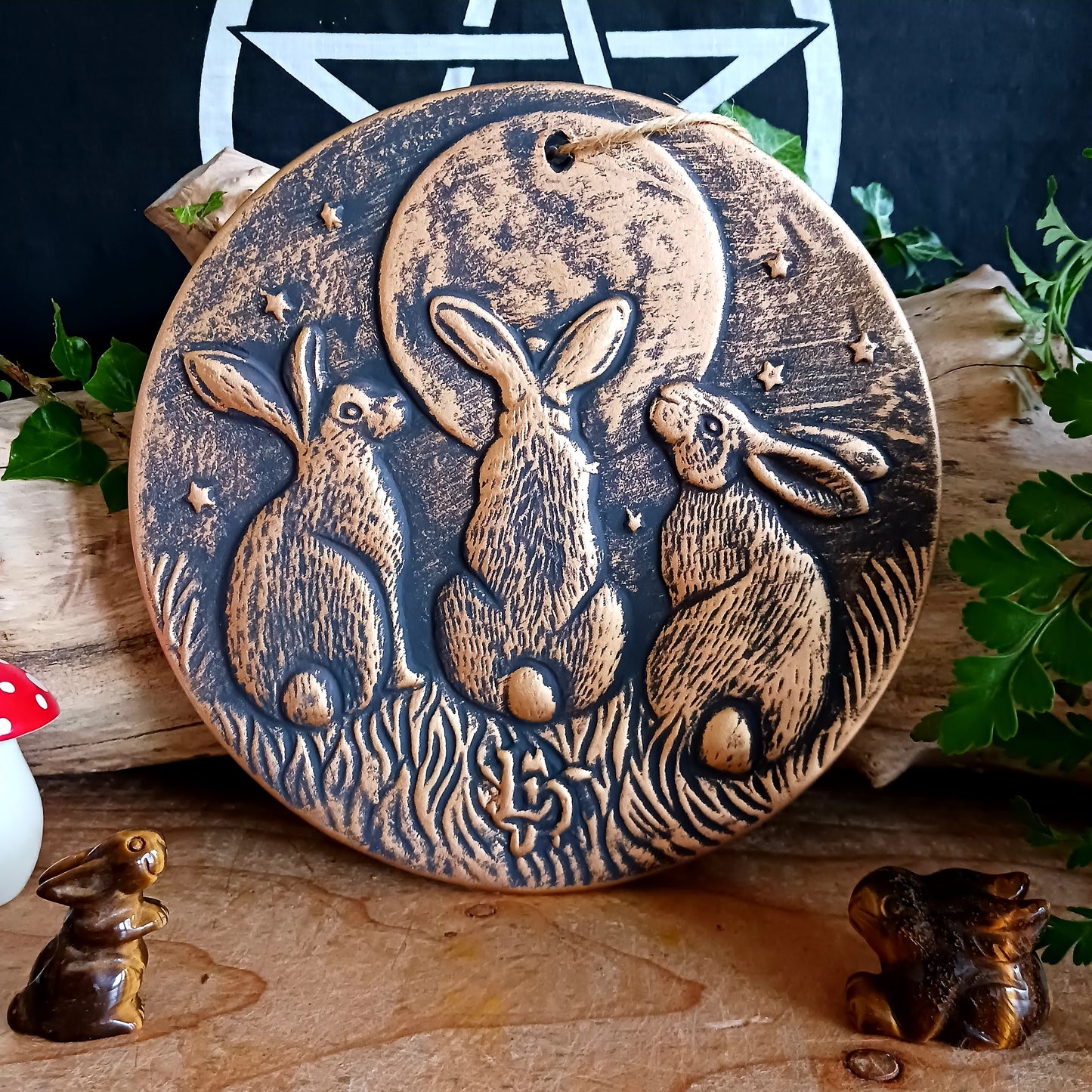 A stunning terracotta wall plaque with a bronze-like effect and striking motif of three moon-gazing hares. This symbol is commonly used to represent fertility and growth. Perfect for garden decor.