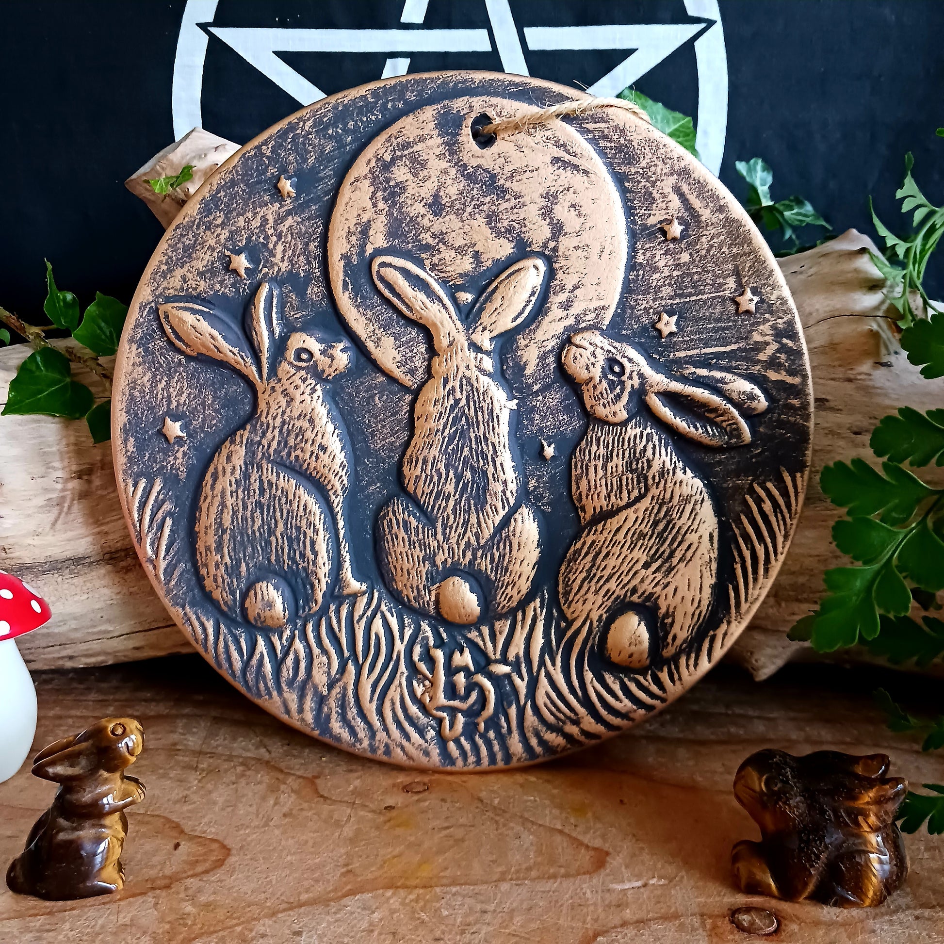 A stunning terracotta wall plaque with a bronze-like effect and striking motif of three moon-gazing hares. This symbol is commonly used to represent fertility and growth. Perfect for garden decor.