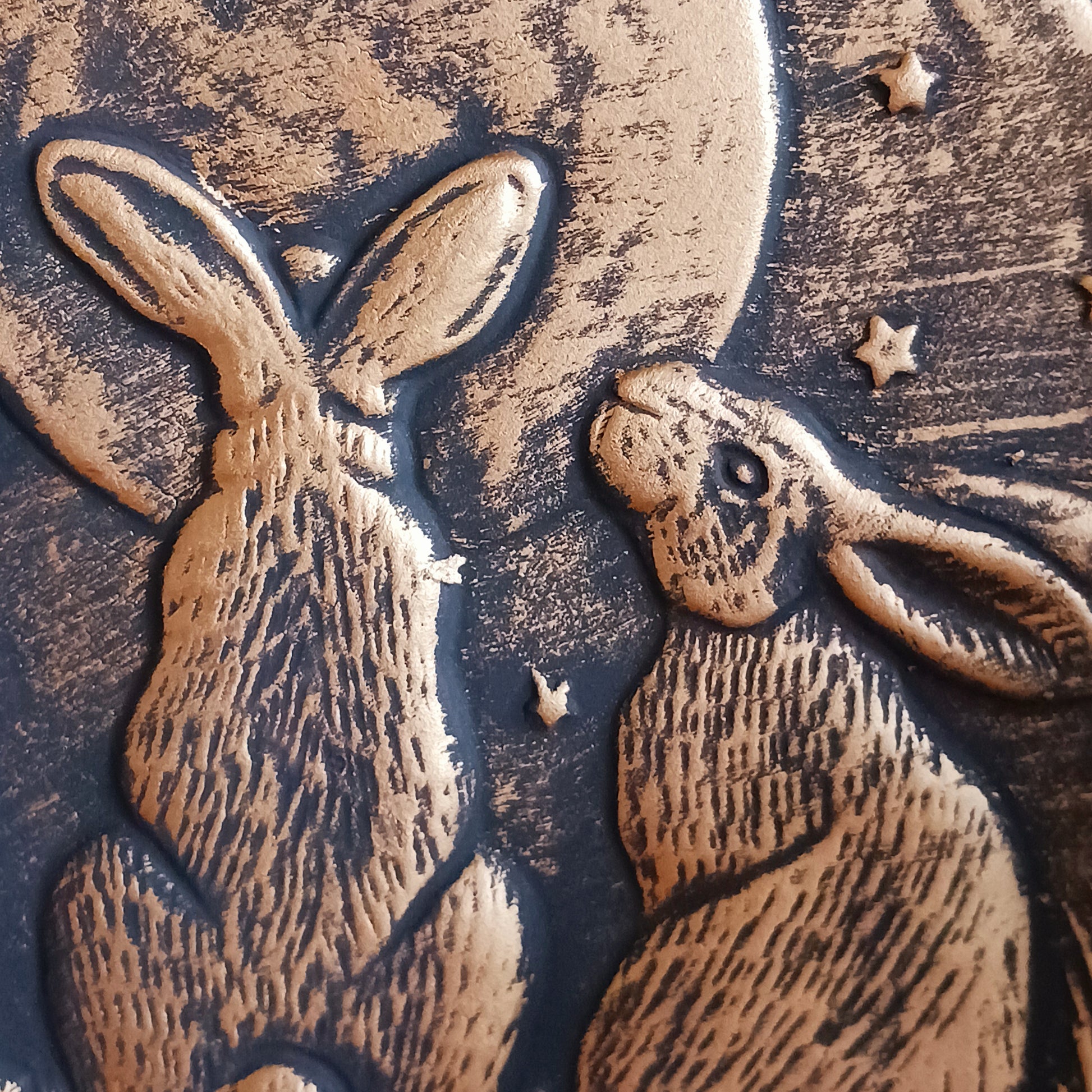 A stunning terracotta wall plaque with a bronze-like effect and striking motif of three moon-gazing hares. This symbol is commonly used to represent fertility and growth. Perfect for garden decor.