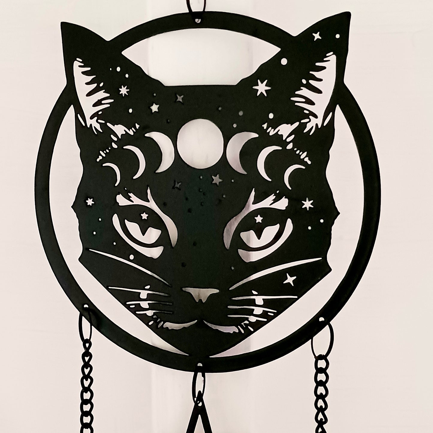 From the Alchemy England hanging decoration collection, this magic black cat face with moon phase and stars has three magical chimes!