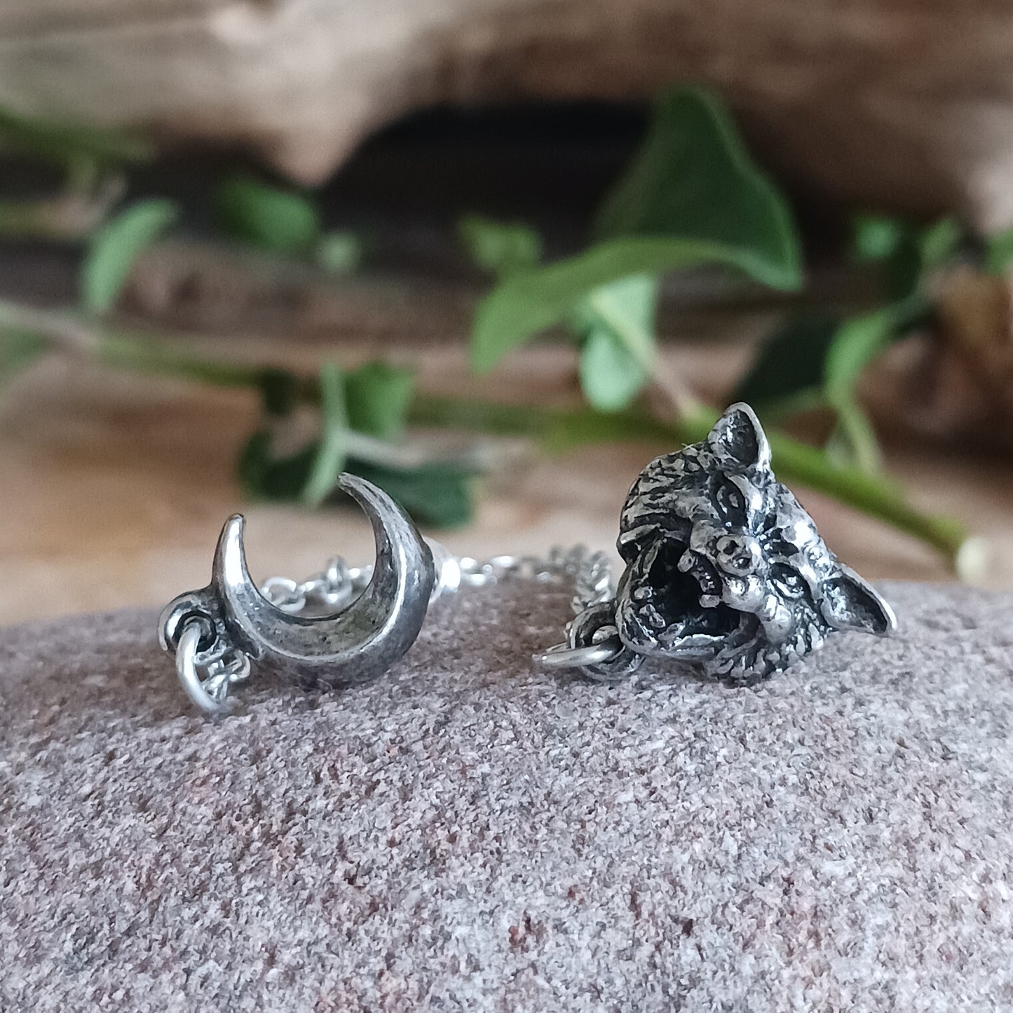 A sullen, skulking lone wolf, sensitive to the nuanced force, awaits a full moon for freedom from restraint.  This enchanting ear jewellery features a crescent moon symbolically linked to a howling wolf by a delicate chain. Perfect for an ear with multiple piercings. Choose how you want to style your ear!