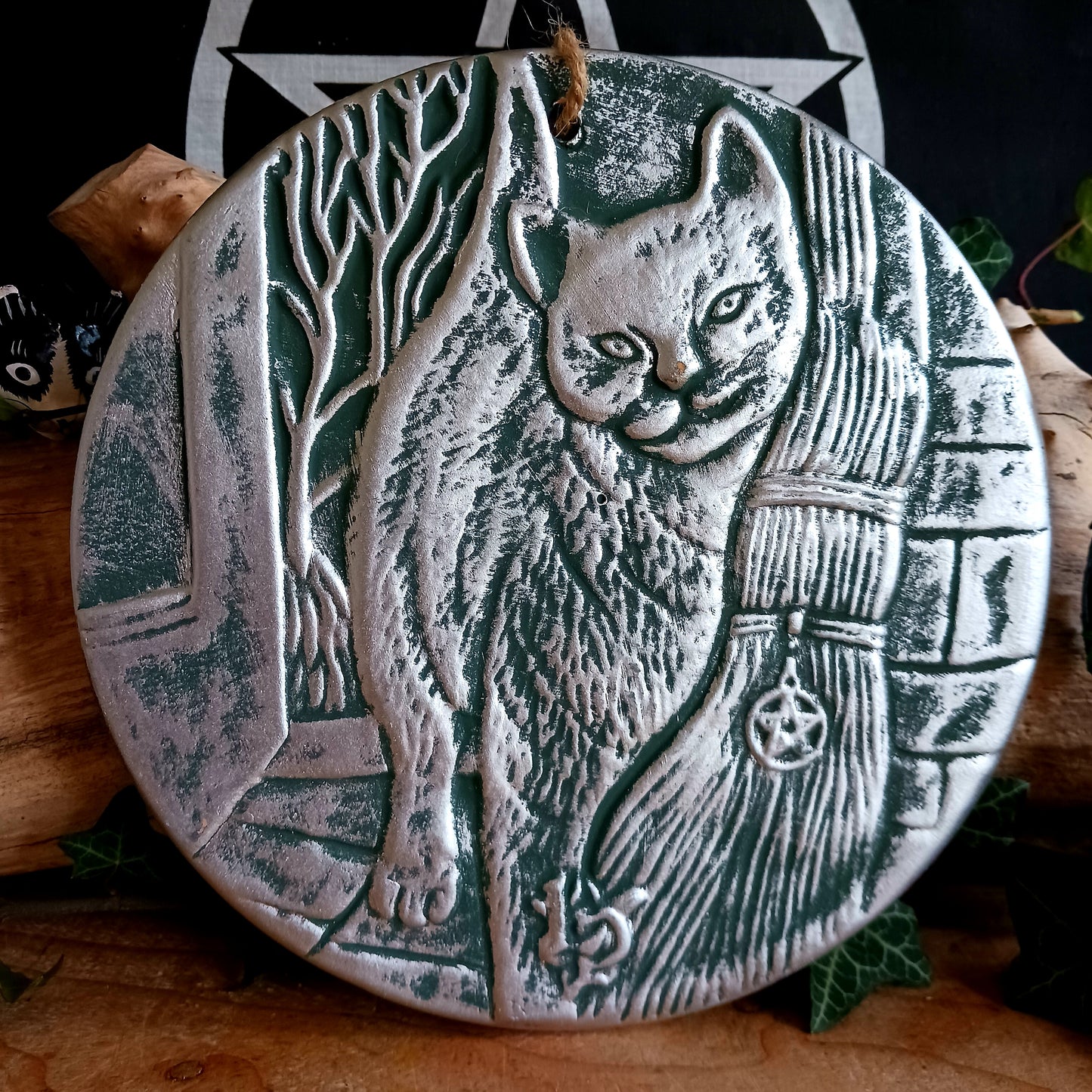 This stunning terracotta wall plaque has a silver-like finish with Lisa Parker's 'A Brush With Magic' artwork featuring a cat and witch's broom.