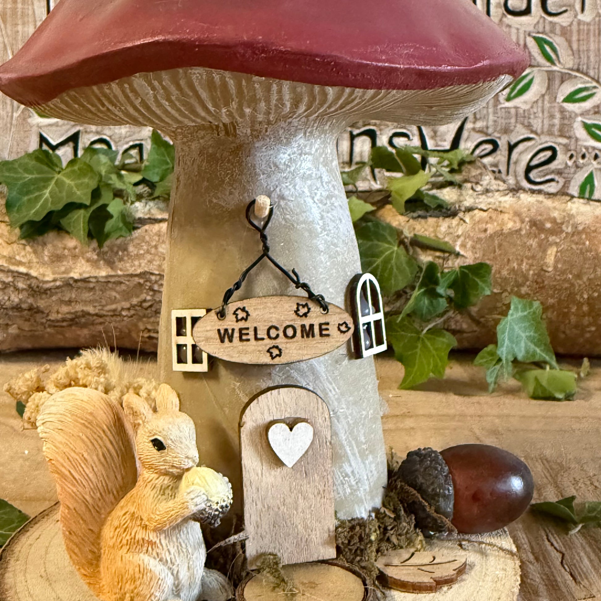 Step into an enchanted woodland with our Folk Art Mushroom Cottage with Squirrel (Large) — a beautifully hand painted fairy house brimming with charm, colour, and storytelling magic. This larger cottage features a vibrant folk art toadstool roof, intricate floral detailing, and a sweet little squirrel perched beside the doorway, as though welcoming visitors into its cosy forest home.