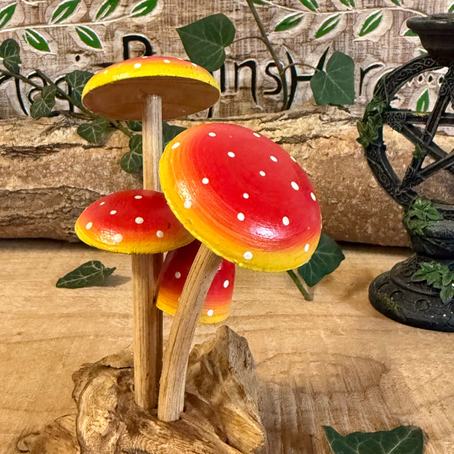 Hand carved red wooden mushrooms on rustic base. Perfect for fairy gardens, cottage-style décor, and whimsical woodland displays in any home.