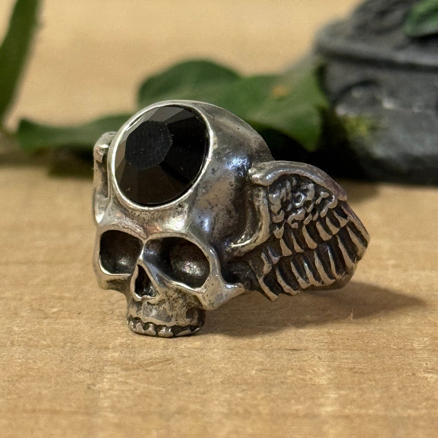 Invoke the balance of strength and spiritual awareness with the Alchemy Gothic Skull and Wings Ring. Crafted from durable black pewter, this ring showcases a detailed skull with outstretched wings, embodying transformation, mortality, and the freedom of the soul.

An embossed black stone rests at its heart, radiating grounding energy and mindfulness. This gothic accessory merges elegance with spiritual symbolism, making it ideal for those who seek both style and contemplation.

Designed to fit size U, this 