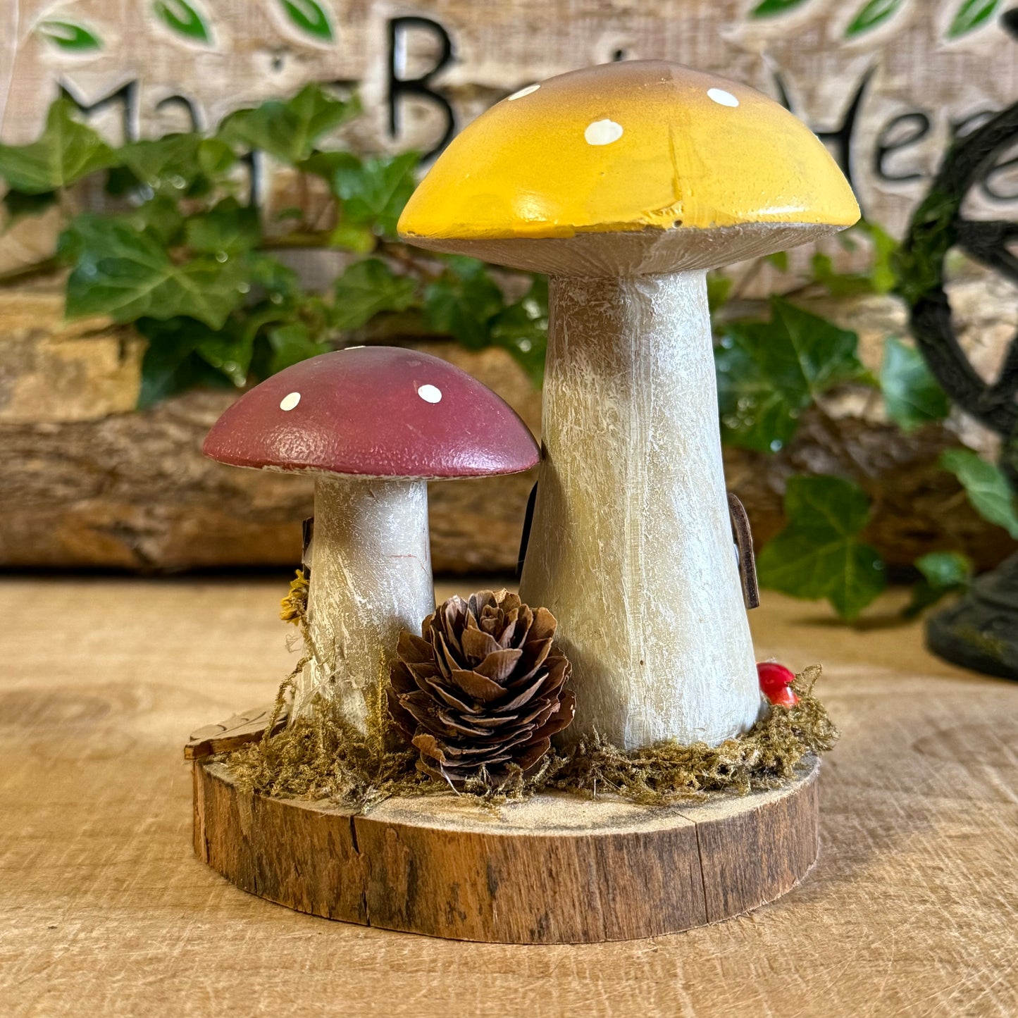 Wander into a whimsical woodland with our Folk Art Mushroom Two Cottages (Tall) — a delightful pair of hand painted fairy houses inspired by rustic village life and the charm of springtime meadows. Each tall mushroom cottage is adorned with bright folk art patterns, floral details, and earthy tones that bring a sense of storybook enchantment to your home.