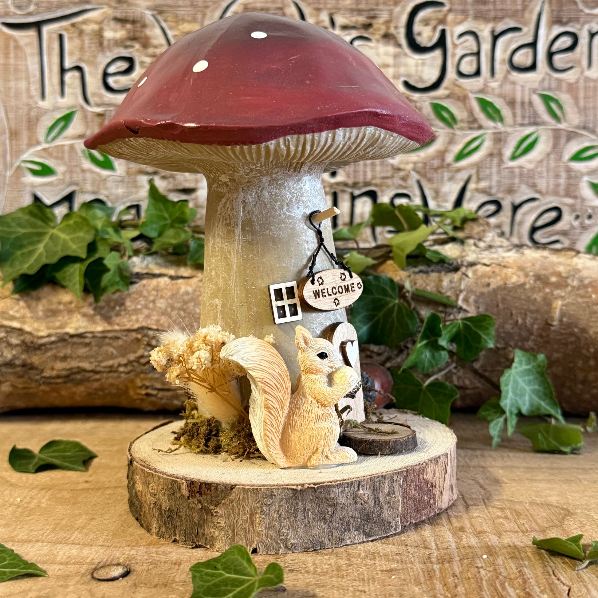 Step into an enchanted woodland with our Folk Art Mushroom Cottage with Squirrel (Large) — a beautifully hand painted fairy house brimming with charm, colour, and storytelling magic. This larger cottage features a vibrant folk art toadstool roof, intricate floral detailing, and a sweet little squirrel perched beside the doorway, as though welcoming visitors into its cosy forest home.