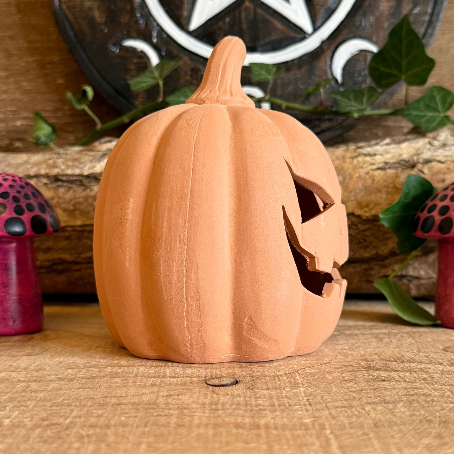 From Buddha Moon, this 12.5cm terracotta pumpkin ornament is the perfect addition to your Halloween décor. Featuring a classic jack-o’-lantern design, it holds a tealight candle to cast a spooky, warm glow indoors or outdoors. Ideal for mantels, tables, patios, or garden displays, this pumpkin combines traditional craftsmanship with festive charm. Durable and stylish, it enhances your Halloween celebrations year after year.