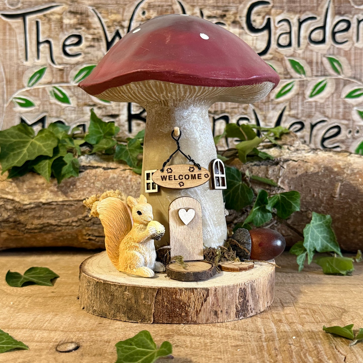 Step into an enchanted woodland with our Folk Art Mushroom Cottage with Squirrel (Large) — a beautifully hand painted fairy house brimming with charm, colour, and storytelling magic. This larger cottage features a vibrant folk art toadstool roof, intricate floral detailing, and a sweet little squirrel perched beside the doorway, as though welcoming visitors into its cosy forest home.