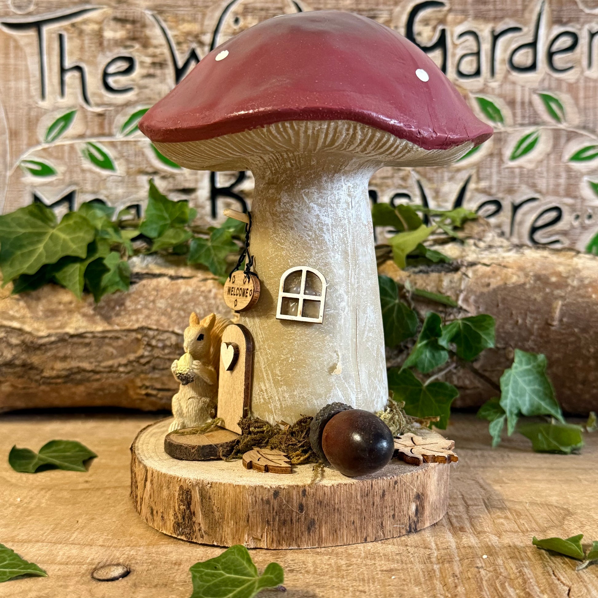 Step into an enchanted woodland with our Folk Art Mushroom Cottage with Squirrel (Large) — a beautifully hand painted fairy house brimming with charm, colour, and storytelling magic. This larger cottage features a vibrant folk art toadstool roof, intricate floral detailing, and a sweet little squirrel perched beside the doorway, as though welcoming visitors into its cosy forest home.