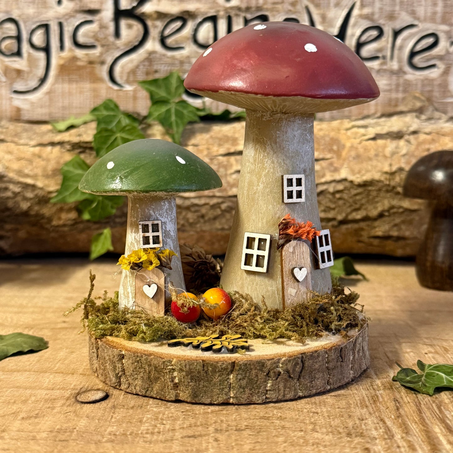 Wander into a whimsical woodland with our Folk Art Mushroom Two Cottages (Tall) — a delightful pair of hand painted fairy houses inspired by rustic village life and the charm of springtime meadows. Each tall mushroom cottage is adorned with bright folk art patterns, floral details, and earthy tones that bring a sense of storybook enchantment to your home.