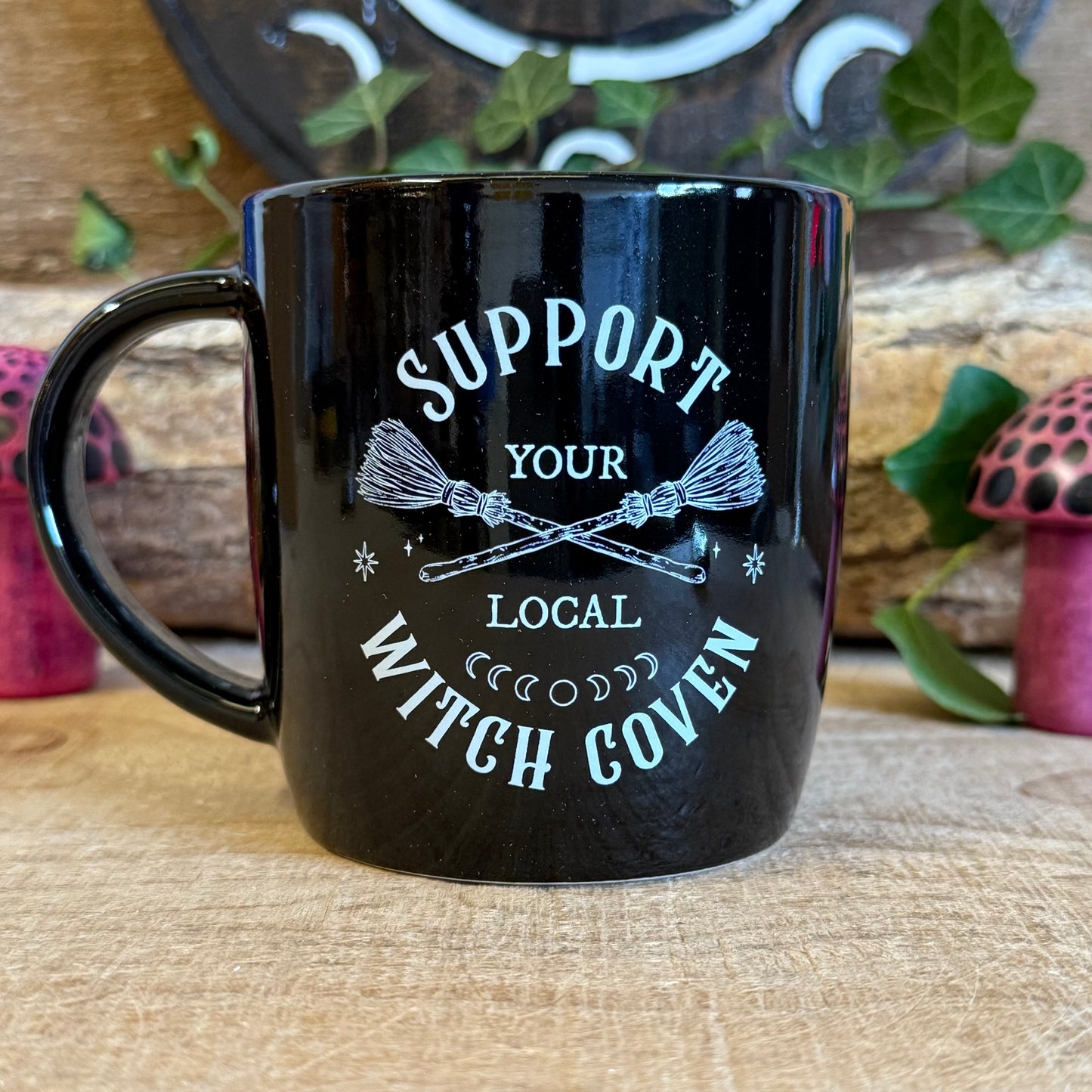 Show your support for all things magical with this black ceramic mug featuring crossed broomsticks and the phrase “Support Your Local Witch Coven.” Perfect for modern witches, mystical coffee lovers, and anyone who proudly backs their coven crew. With a 320ml capacity, it’s ideal for coffee, tea, or any magical potion. Microwave and dishwasher safe, this mug combines practicality with witchy style, making it a must-have gift or a charming addition to your own mystical collection.