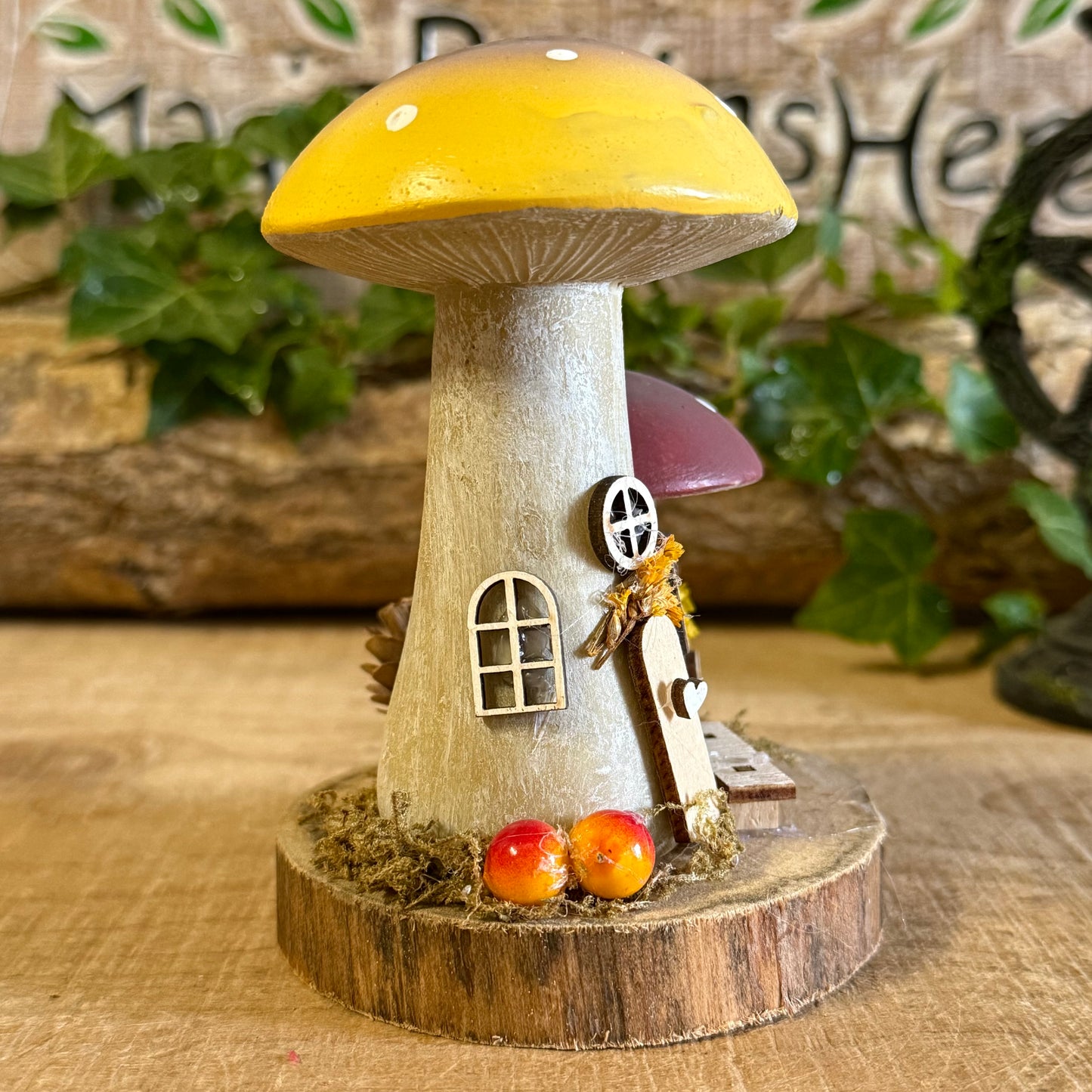 Wander into a whimsical woodland with our Folk Art Mushroom Two Cottages (Tall) — a delightful pair of hand painted fairy houses inspired by rustic village life and the charm of springtime meadows. Each tall mushroom cottage is adorned with bright folk art patterns, floral details, and earthy tones that bring a sense of storybook enchantment to your home.