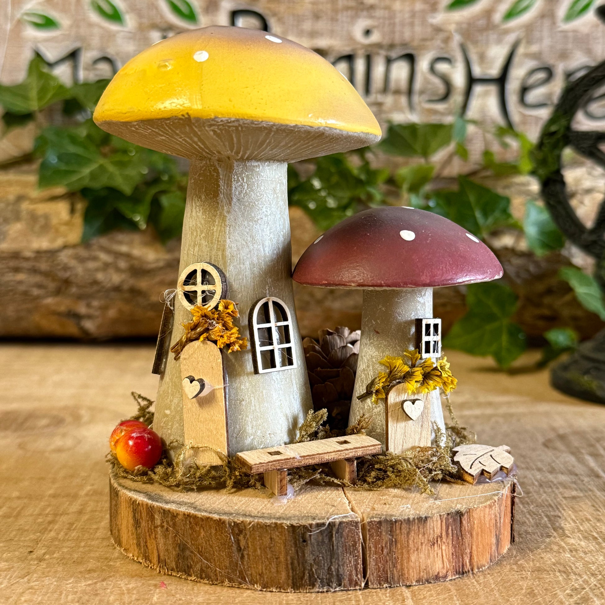 Wander into a whimsical woodland with our Folk Art Mushroom Two Cottages (Tall) — a delightful pair of hand painted fairy houses inspired by rustic village life and the charm of springtime meadows. Each tall mushroom cottage is adorned with bright folk art patterns, floral details, and earthy tones that bring a sense of storybook enchantment to your home.