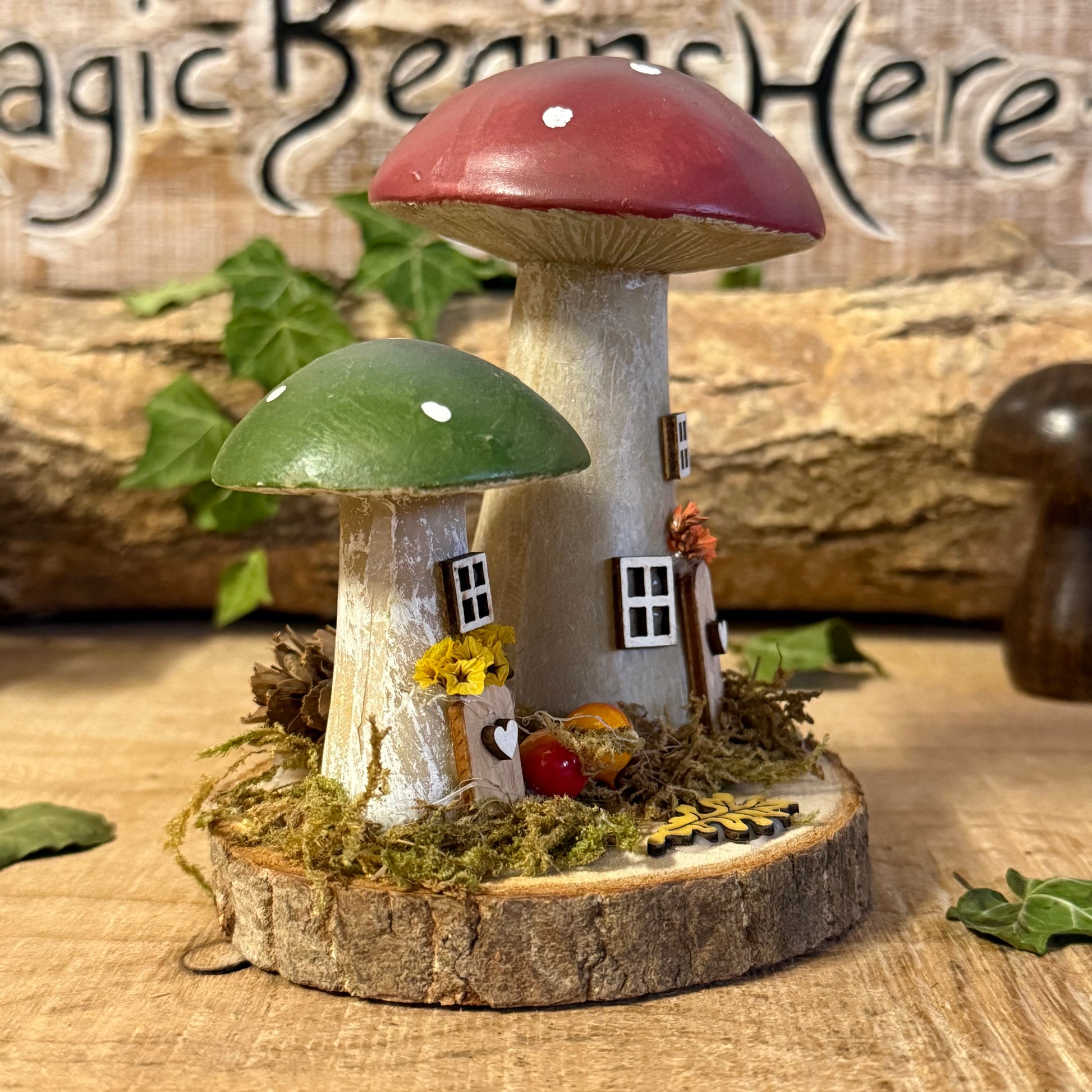Wander into a whimsical woodland with our Folk Art Mushroom Two Cottages (Tall) — a delightful pair of hand painted fairy houses inspired by rustic village life and the charm of springtime meadows. Each tall mushroom cottage is adorned with bright folk art patterns, floral details, and earthy tones that bring a sense of storybook enchantment to your home.