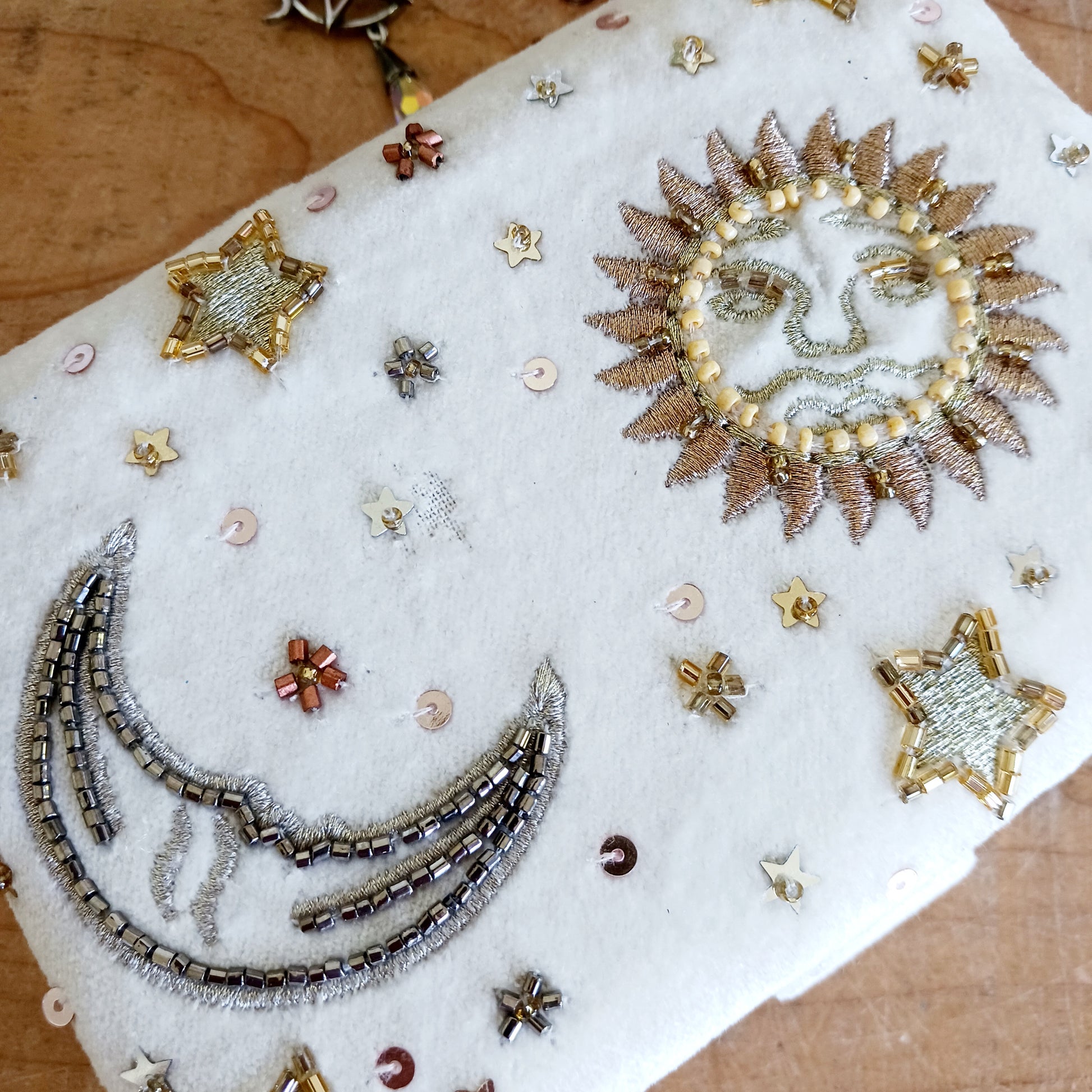 Add elegance and mystique to your collection with this finely embroidered jewellery and tarot box. Made in India and crafted from soft velvet in white, this piece is adorned with intricate embroidery and golden ornamental beads for a touch of luxury. Perfect for storing jewellery, tarot cards, crystals, or other cherished items, its small strap and button closure keep your treasures secure.