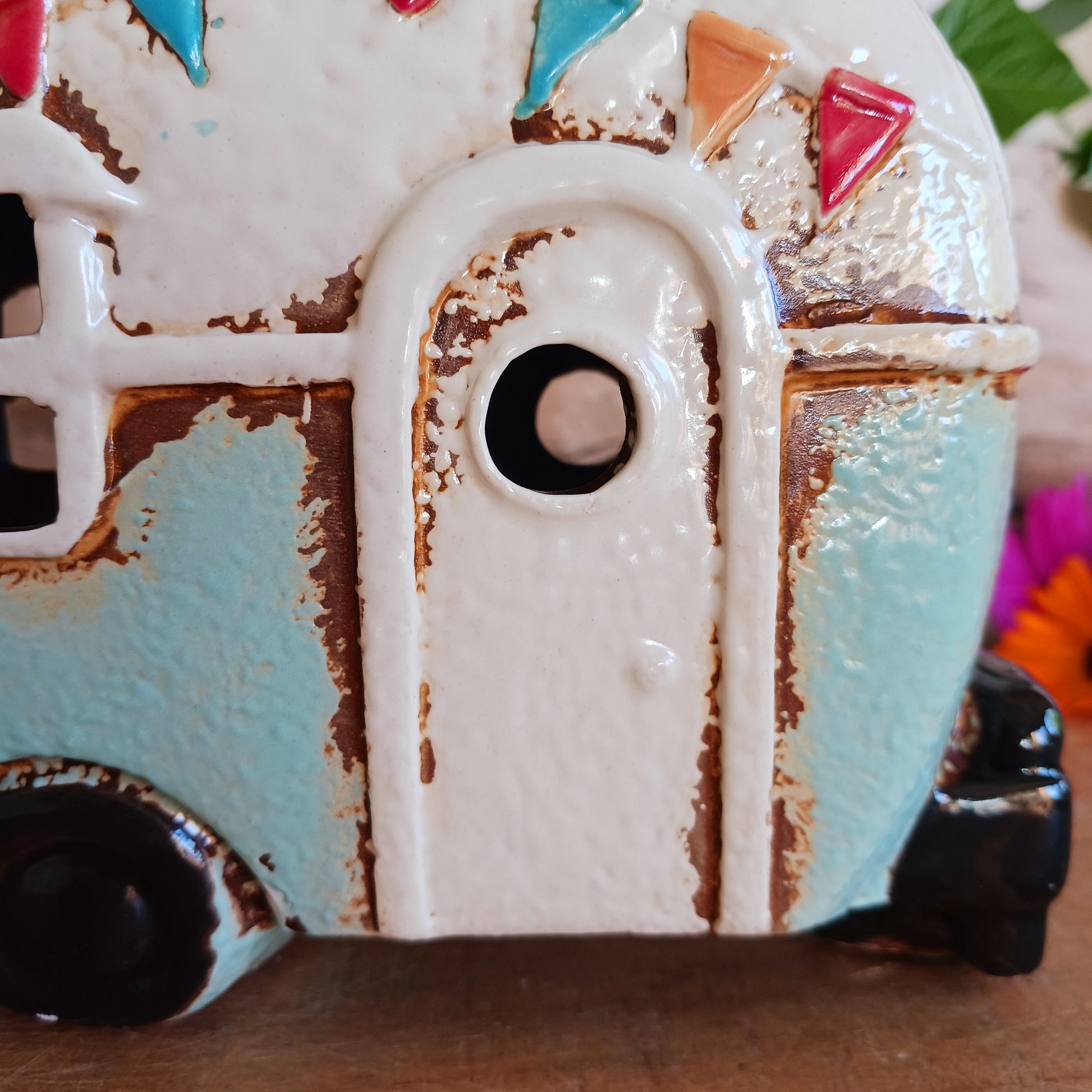 From the enchanted lanes of Village Pottery comes this Aqua Caravan Money Box, a charming ceramic treasure crafted for dreamers and wanderers alike. Measuring 13.5 x 18.5 x 6.5 cm, this delightful piece captures the spirit of adventure with its soft aqua glaze, vintage caravan design, and hand-painted detailing that feels kissed by fairy dust.