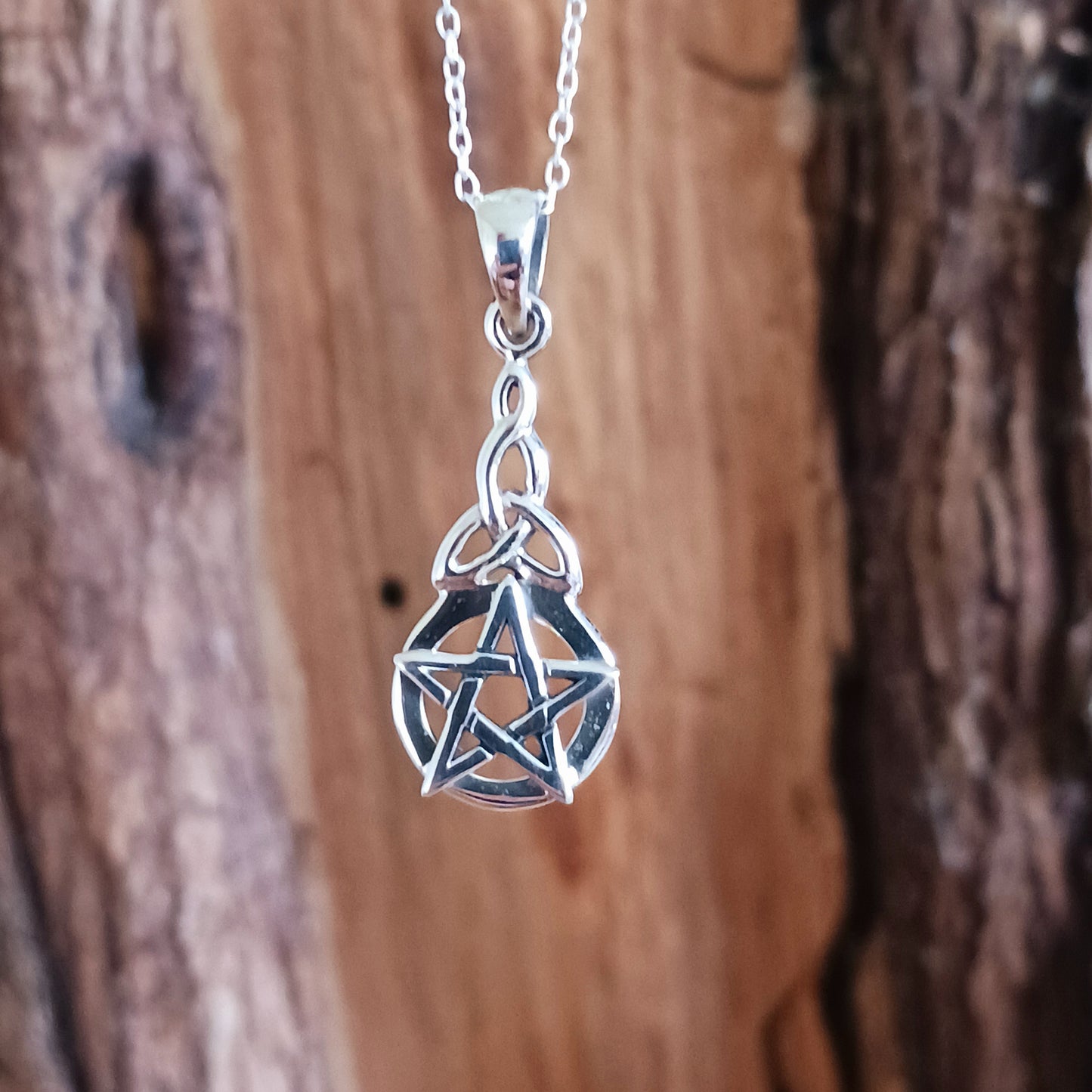 This beautiful pendant creates a significant and luminous amulet. The design is vertically oriented, featuring two distinct but harmoniously linked symbols. At the base is a prominent, circular Five-Pointed Star (Pentacle/Pentagram), the classic symbol of protection and the balanced harmony of the five elements.