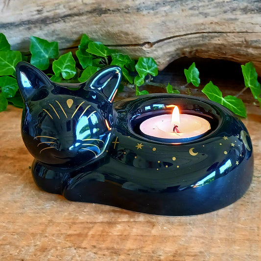 Create a warm and mystical atmosphere with this charming black cat ceramic tealight holder. Designed in the shape of a peacefully curled cat, this decorative candle holder adds a soft flickering glow to shelves, bedside tables, altars, and cosy corners of your home.
