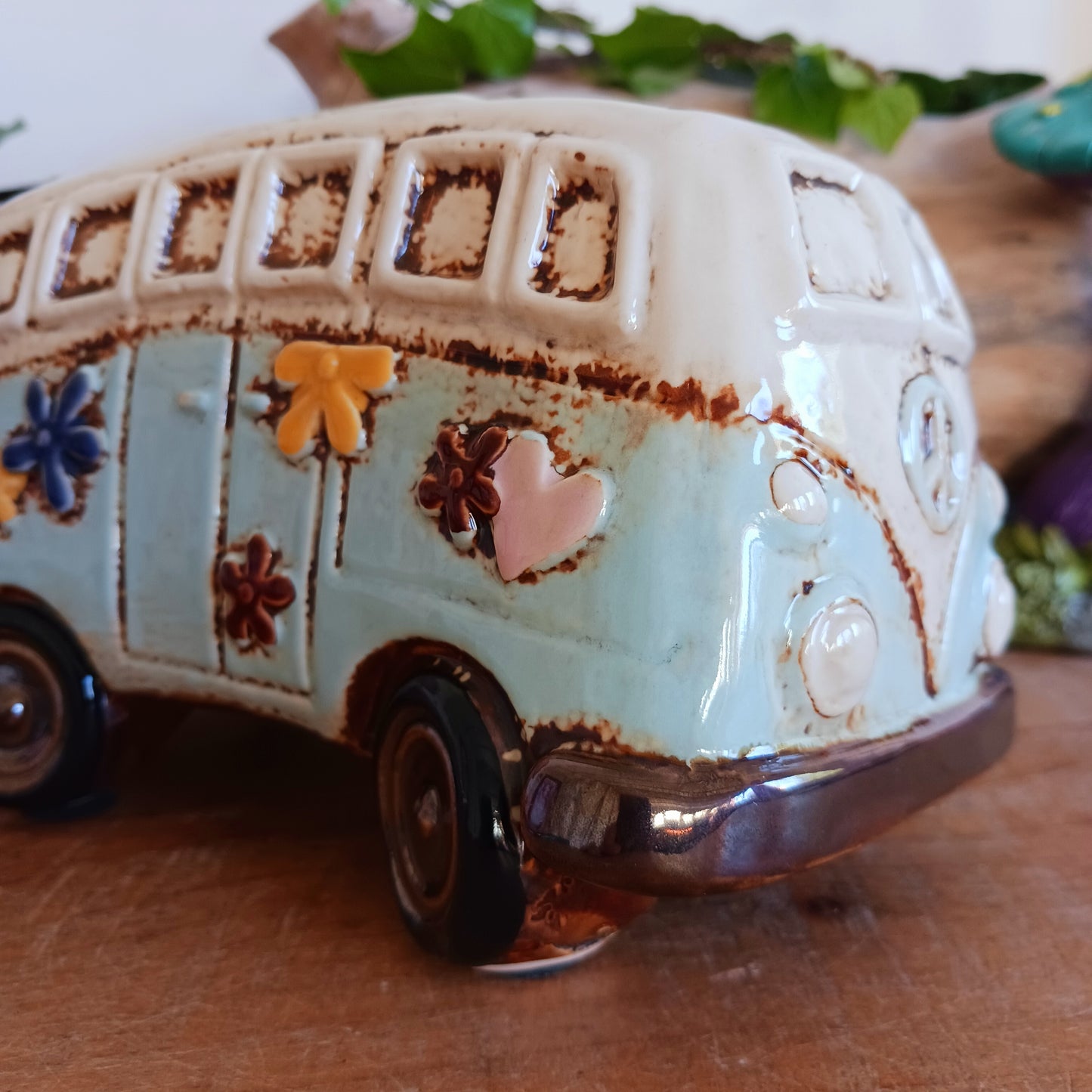 From the enchanted lanes of Village Pottery comes this Aqua VW Campervan Money Box, a charming ceramic treasure crafted for dreamers and wanderers alike. Measuring 11 x 18.5 x 10cm, this delightful piece captures the spirit of adventure with its soft aqua glaze, vintage VW Campervan design, and hand-painted detailing that feels kissed by fairy dust.