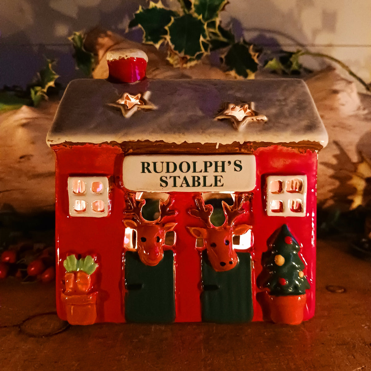 Bring a touch of festive village charm to your home with the Village Pottery Xmas Rudolph’s Stable Tealight Holder. This delightful ceramic Christmas decoration is designed as a quaint little stable, featuring a snowy roof, traditional green doors and charming reindeer detailing.