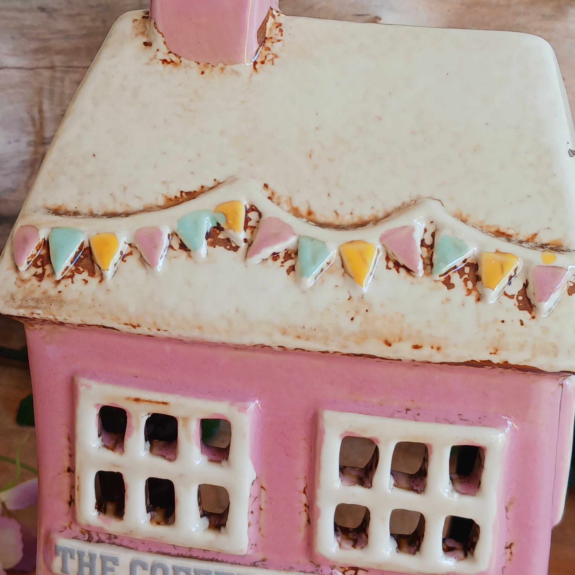 A comforting glow brews within the Coffee Pot Shop, where candlelight flickers like steam rising from a warm cup in a quiet enchanted village. This Shudehill Village Pottery tealight house is crafted from ceramic, casting a soft, golden light through its windows to create a scene of calm and gentle magic.